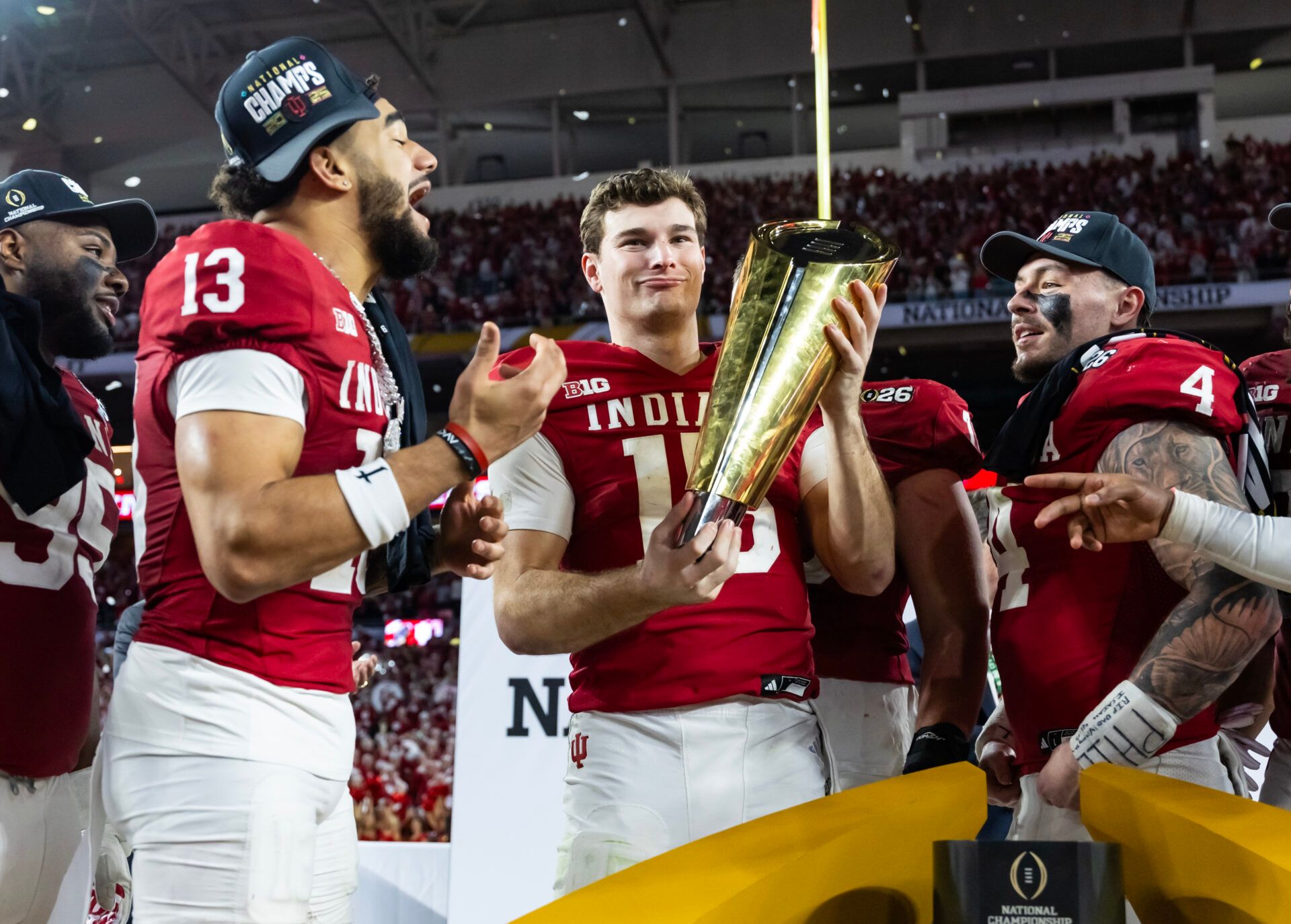 Indiana Hoosiers quarterback Fernando Mendoza (16) holds the trophy as he celebrates with wide receiver Elijah Sarratt (13) and linebacker Aiden Fisher (4) after defeating the Miami Hurricanes in the College Football Playoff National Championship game at Hard Rock Stadium.