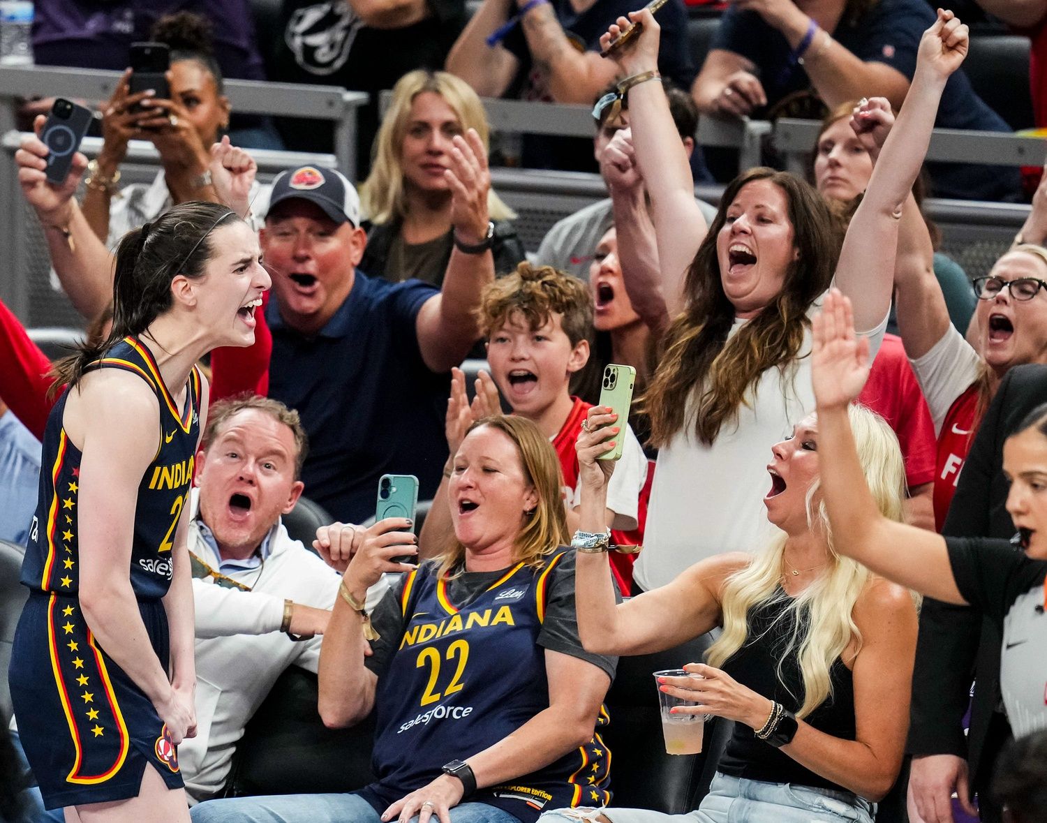 Indiana Fever guard Caitlin Clark (22) celebrates with fans after scoring a 3-pointer during a game between the Indiana Fever and the Connecticut Sun at Gainbridge Fieldhouse in Indianapolis, Ind., on Tuesday, June 17, 2025. The Indiana Fever defeated the Connecticut Sun, 88-71.