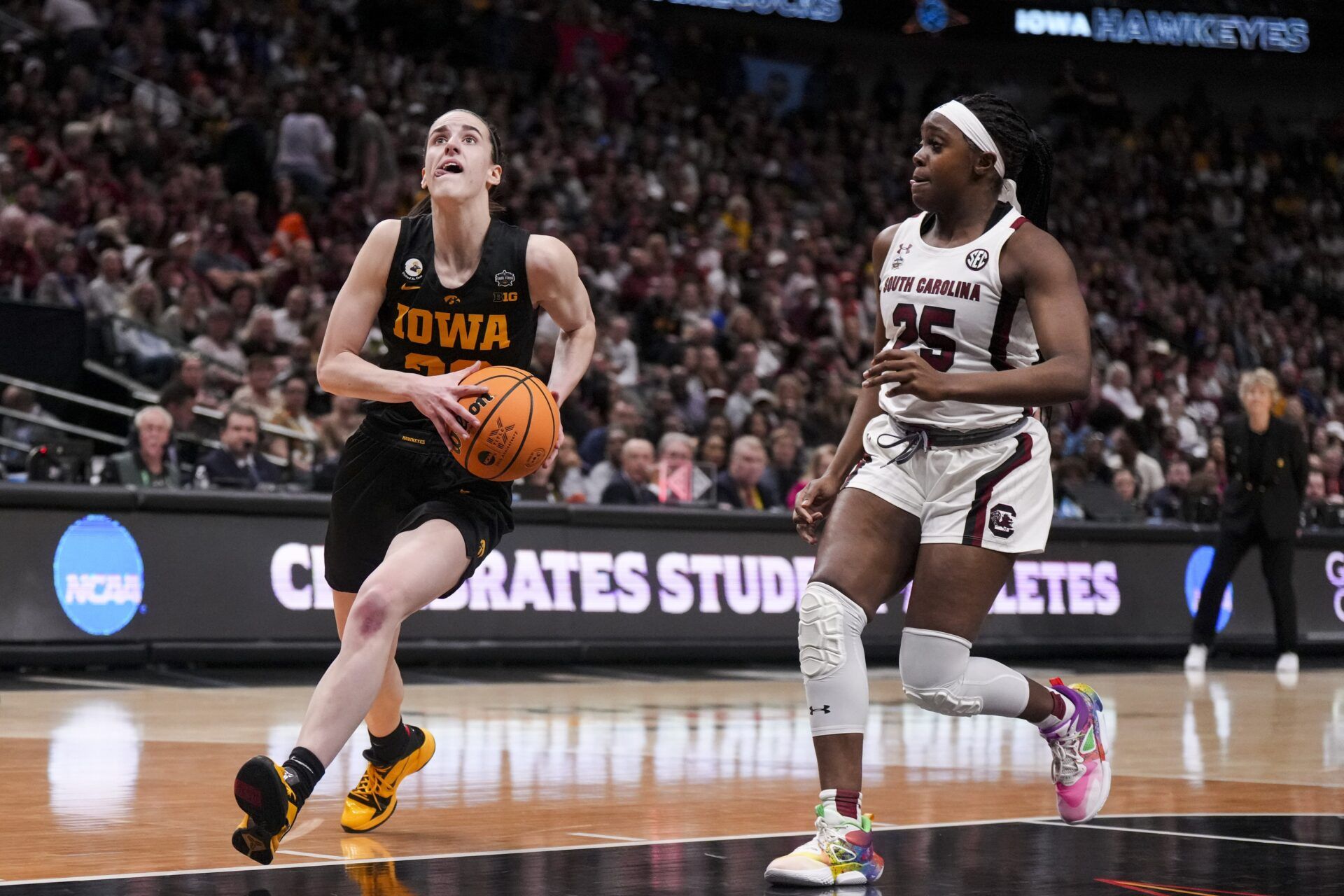 Iowa Hawkeyes guard Caitlin Clark (22) drives to the basket against South Carolina Gamecocks guard Raven Johnson (25) in the first half in semifinals of the women's Final Four of the 2023 NCAA Tournament at American Airlines Center.