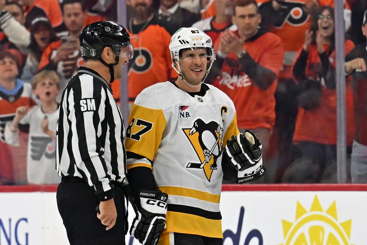 Pittsburgh Penguins center Sidney Crosby (87) is escorted to the penalty box by linesman Jonny Murray (95) against the Philadelphia Flyers during the second period in game three of the first round of the 2026 Stanley Cup Playoffs at Xfinity Mobile Arena.