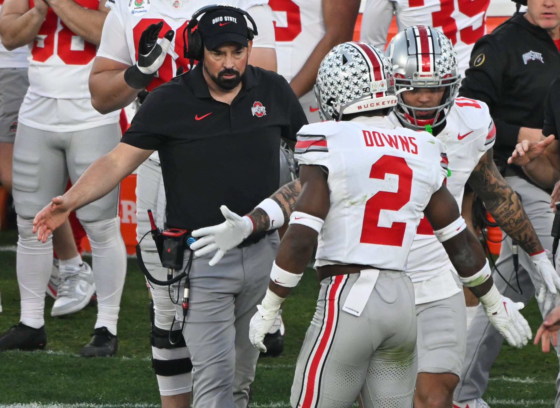 Ohio State Buckeyes head coach Ryan Day greets safety Caleb Downs as he returns to the bench during the third quarter at Rose Bowl Stadium.