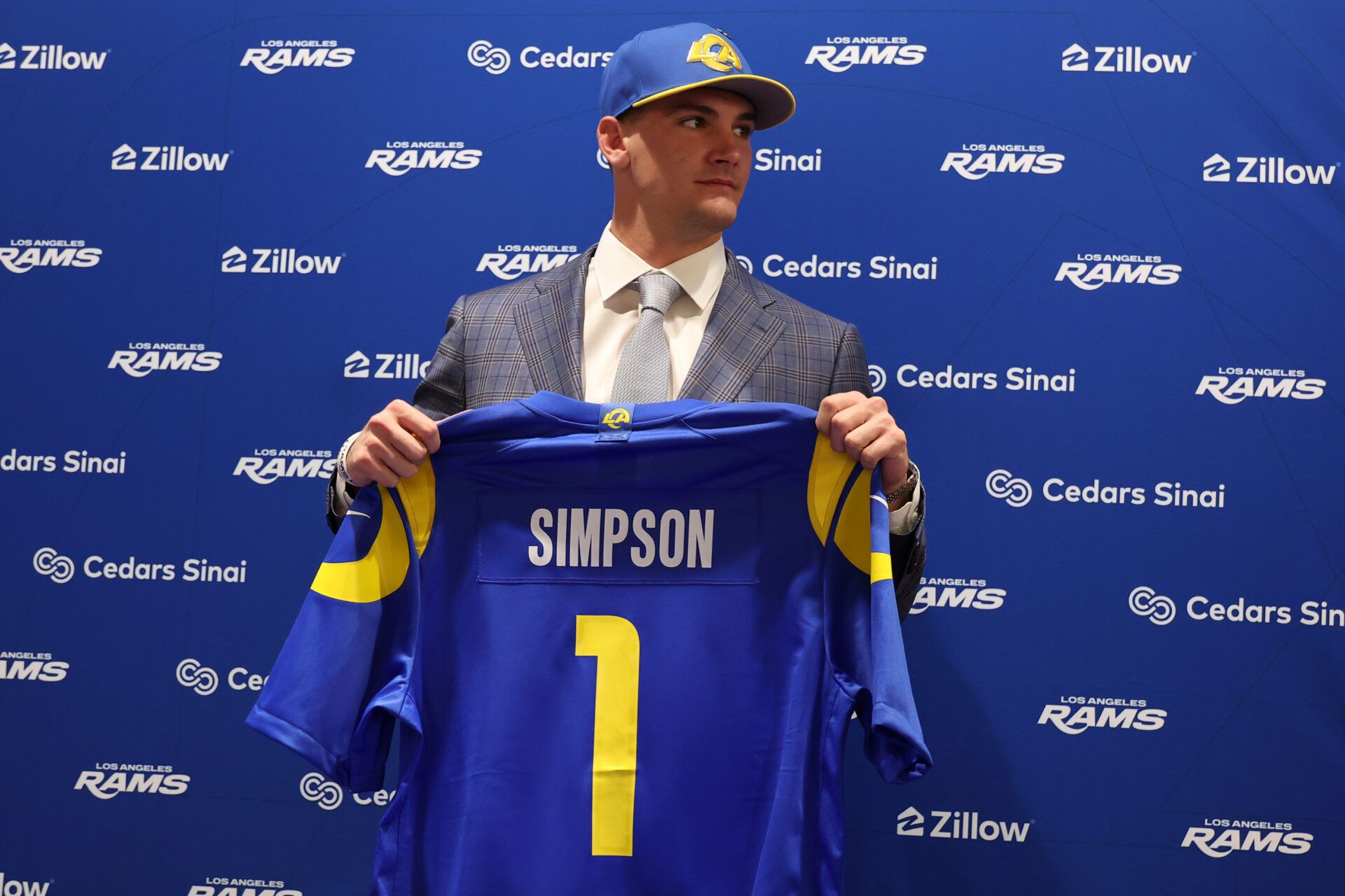 Los Angeles Rams first-round draft pick Ty Simpson poses with his jersey during a press conference at Code Next at Hollywood Park.