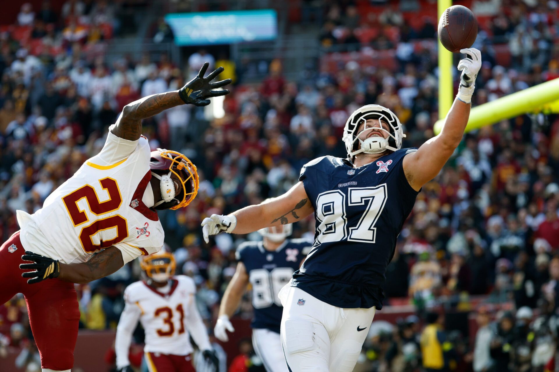 Dallas Cowboys tight end Jake Ferguson (87) makes a catch for a touchdown defended by Washington Commanders safety Quan Martin (20) in the first quarter at Northwest Stadium.