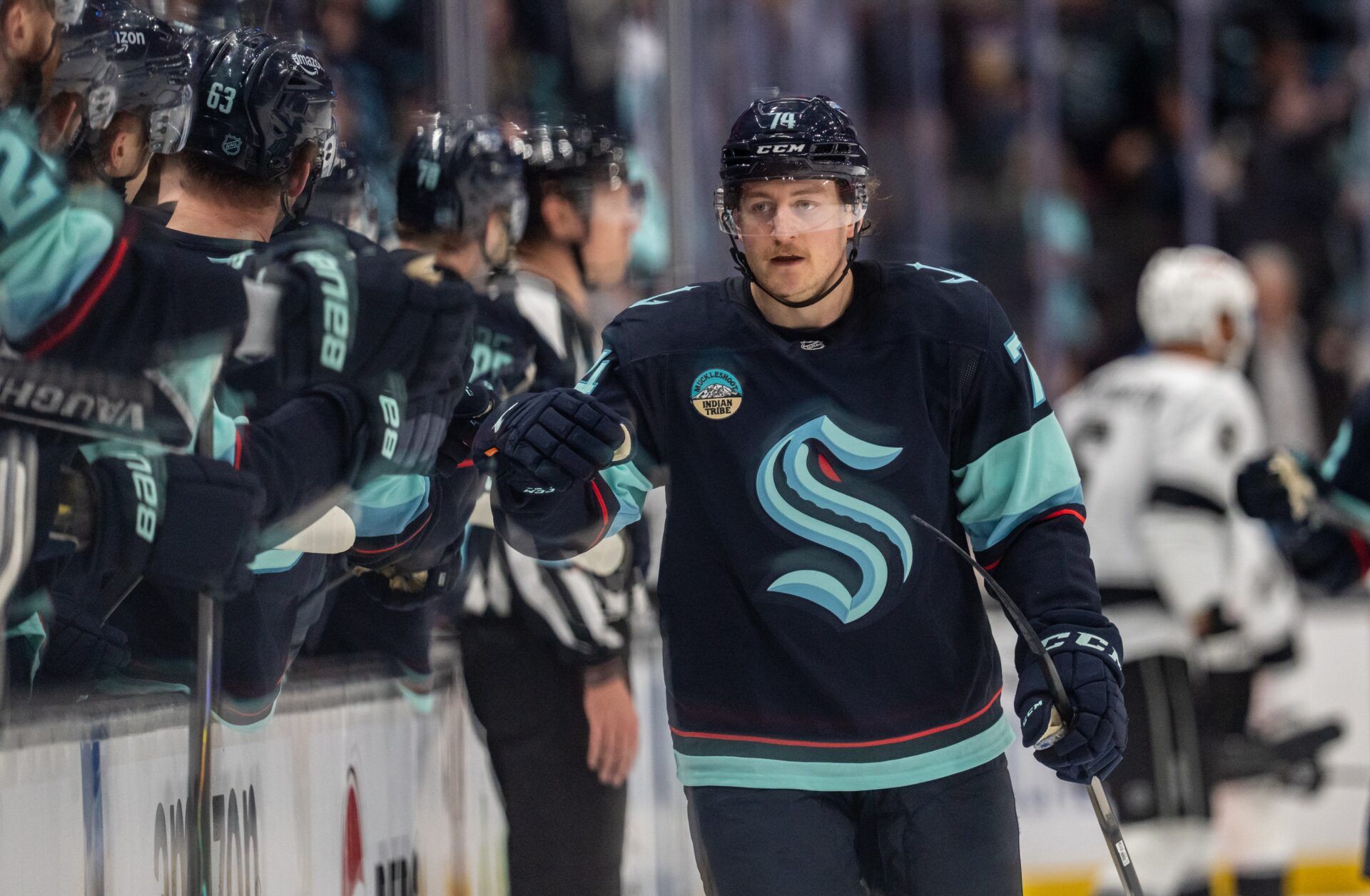 Seattle Kraken forward Bobby McMann (74) is congratulated by teammates on the bench after scoring a goal during the third period against the Los Angeles Kings at Climate Pledge Arena.