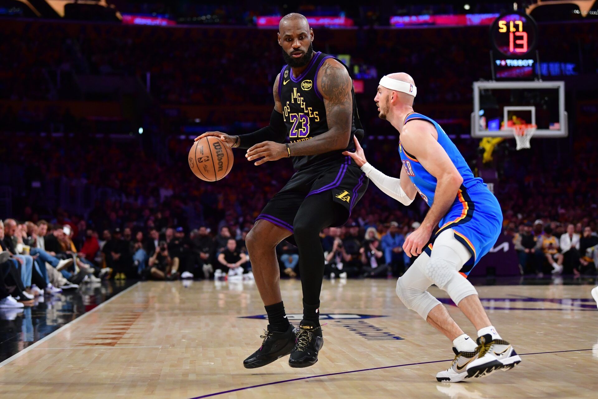 Los Angeles Lakers forward LeBron James (23) moves the ball against Oklahoma City Thunder guard Alex Caruso (9) during the first half in game four of the second round of the 2026 NBA Playoffs at Crypto.com Arena.