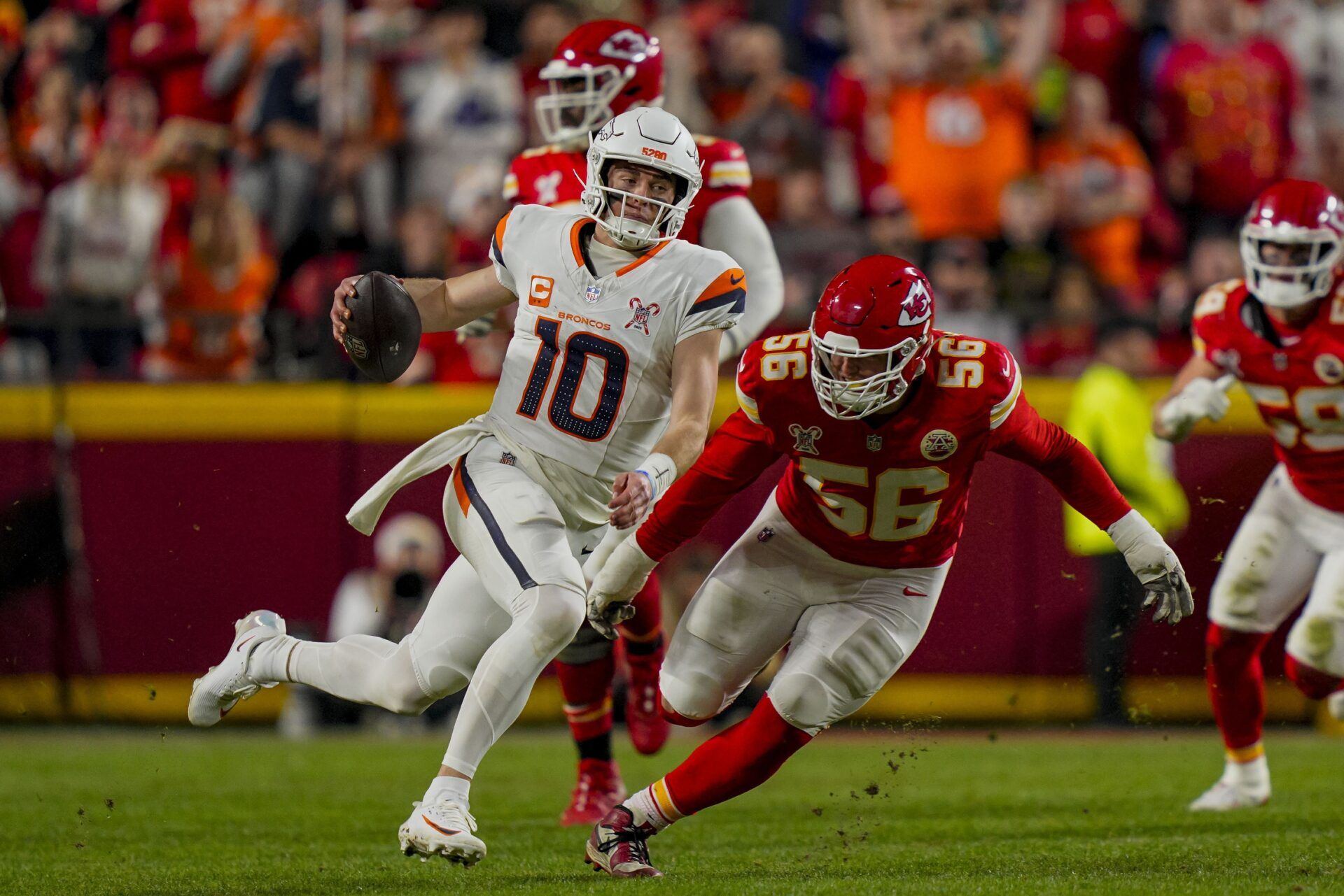 Denver Broncos quarterback Bo Nix (10) runs against Kansas City Chiefs defensive end George Karlaftis (56) during the second quarter at GEHA Field at Arrowhead Stadium.