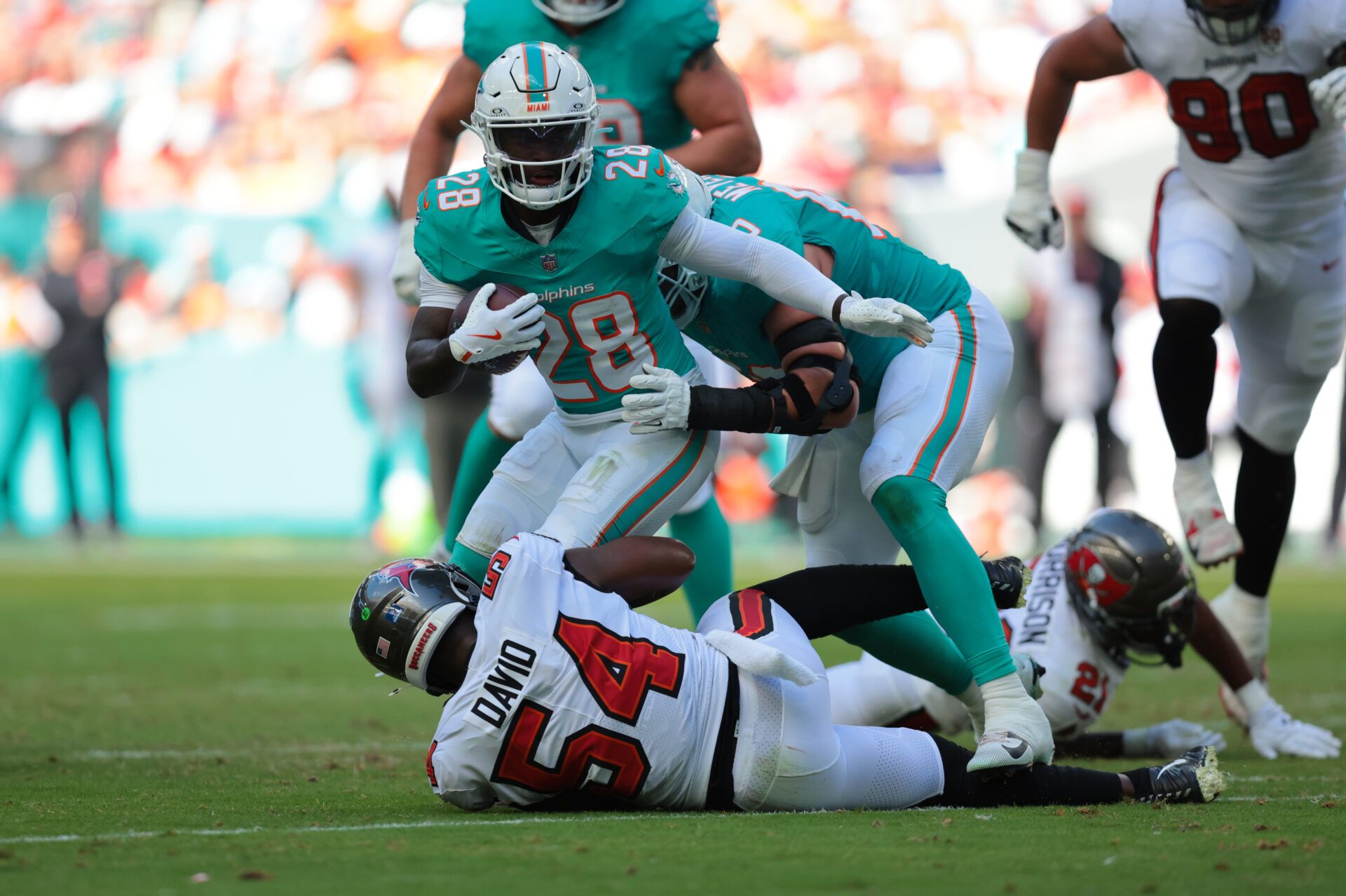 Miami Dolphins running back De'Von Achane (28) is tackled by Tampa Bay Buccaneers linebacker Lavonte David (54) during the second quarter at Hard Rock Stadium.