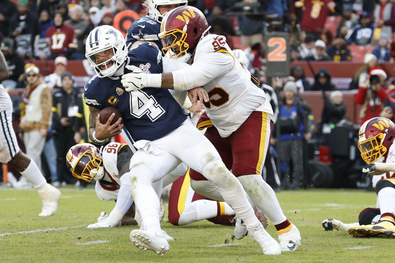 Dallas Cowboys quarterback Dak Prescott (4) is sacked by Washington Commanders defensive tackle Jer'Zhan Newton (95) during the second half at Northwest Stadium.