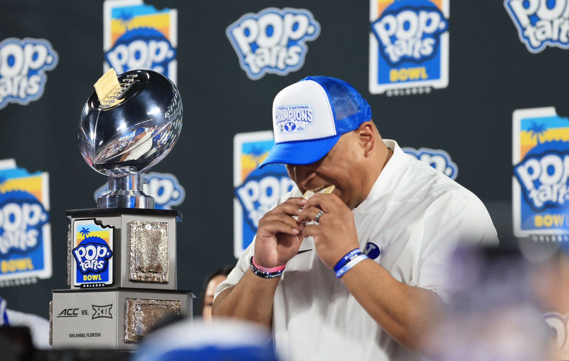 BYU Cougars head coach Kalani Sitake  eats a pop-tart and celebrates after they beat the against the Georgia Tech Yellow Jackets at Camping World Stadium.