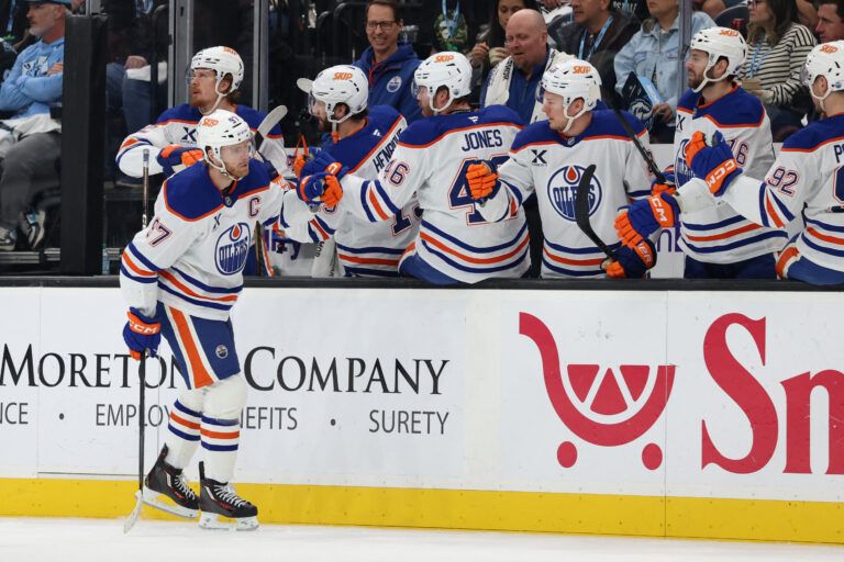 Edmonton Oilers center Connor McDavid (97) celebrates with the bench player at Delta Center.