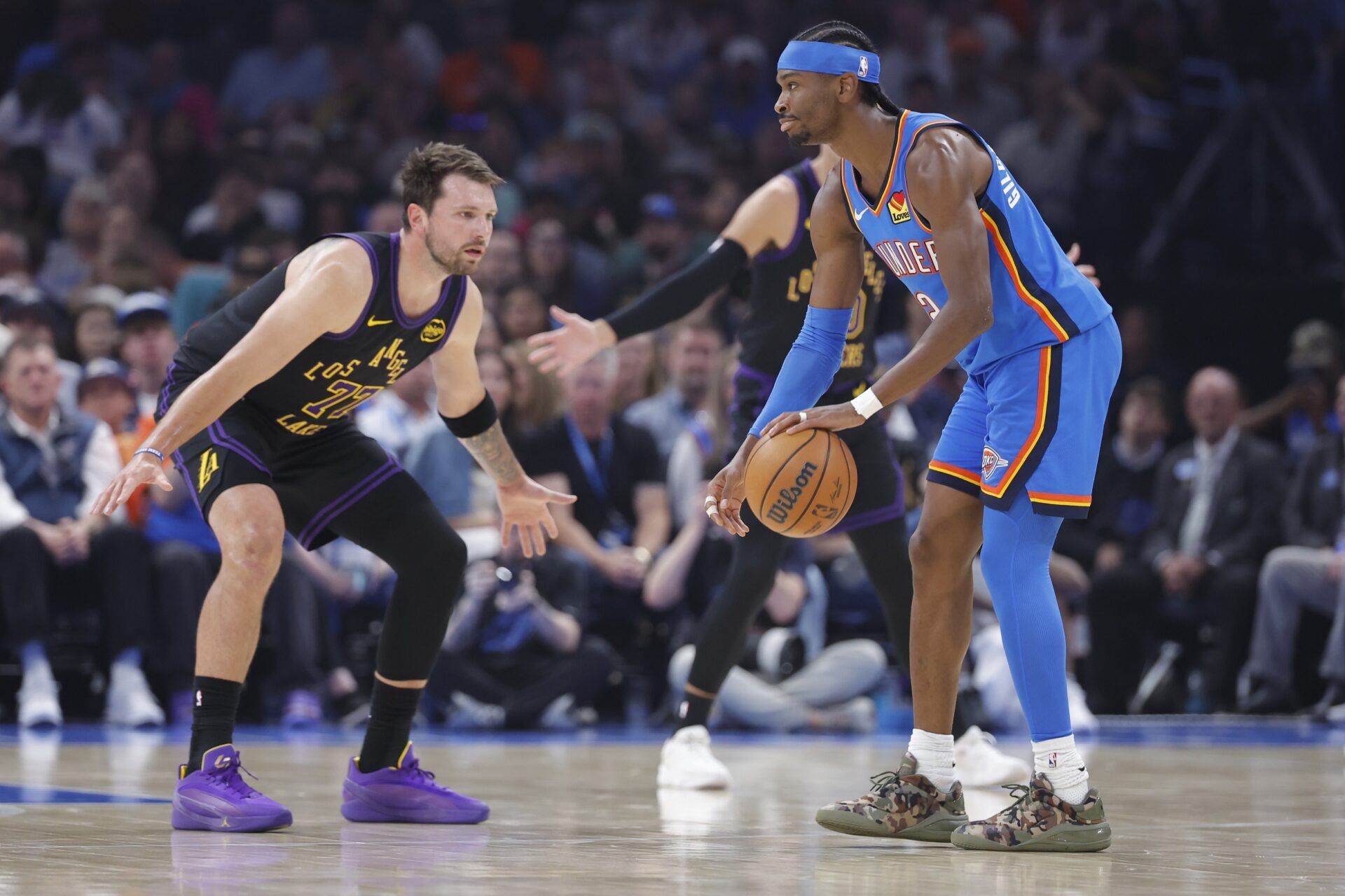 Oklahoma City Thunder guard Shai Gilgeous-Alexander (2) dribbles as Los Angeles Lakers guard Luka Doncic (77) defends during the first quarter at Paycom Center.