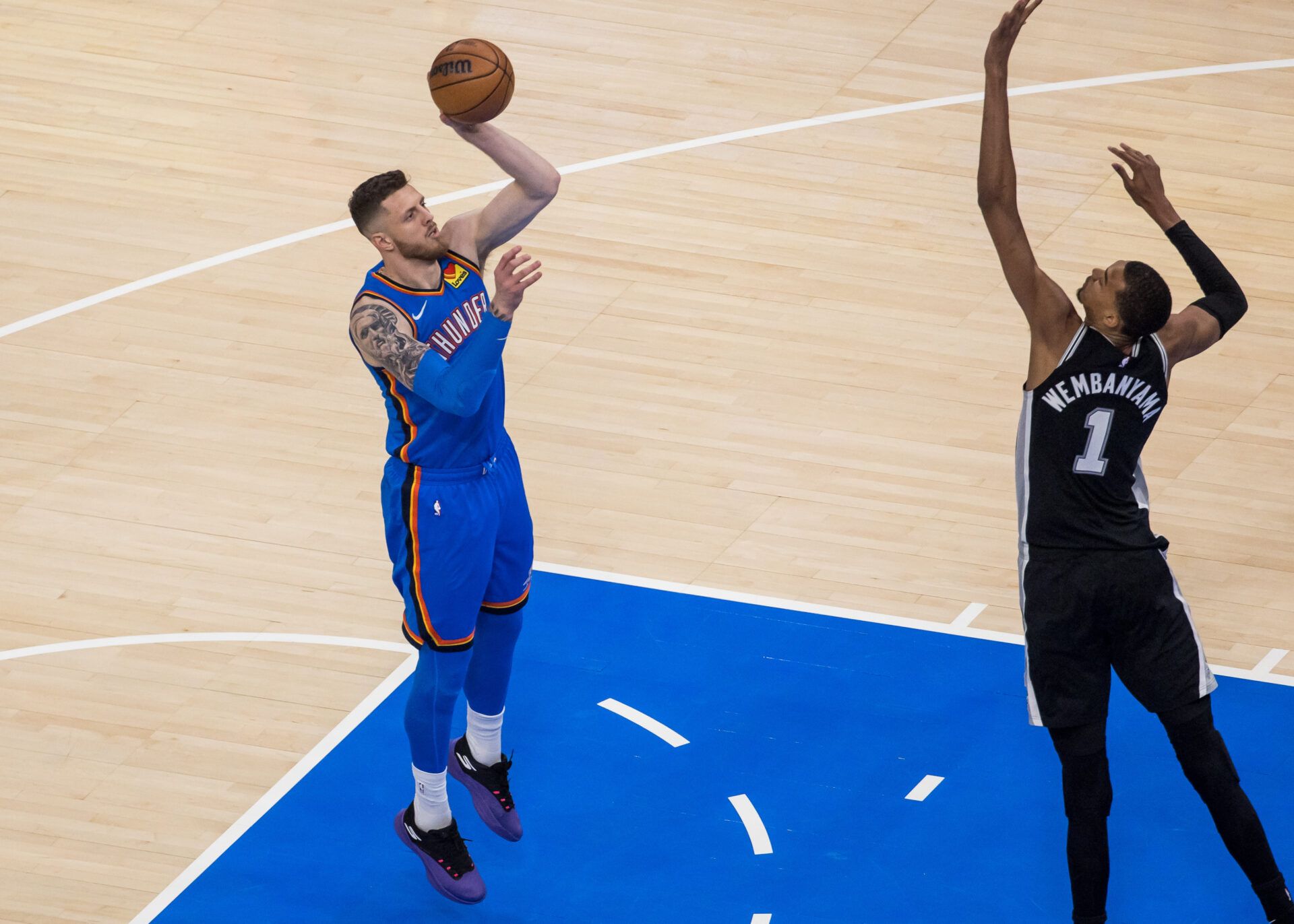 Oklahoma City Thunder center/forward Isaiah Hartenstein (55) shoots while defended by San Antonio Spurs center Victor Wembanyama (1) in the first quarter during game one of the western conference finals for the 2026 NBA playoffs at Paycom Center.