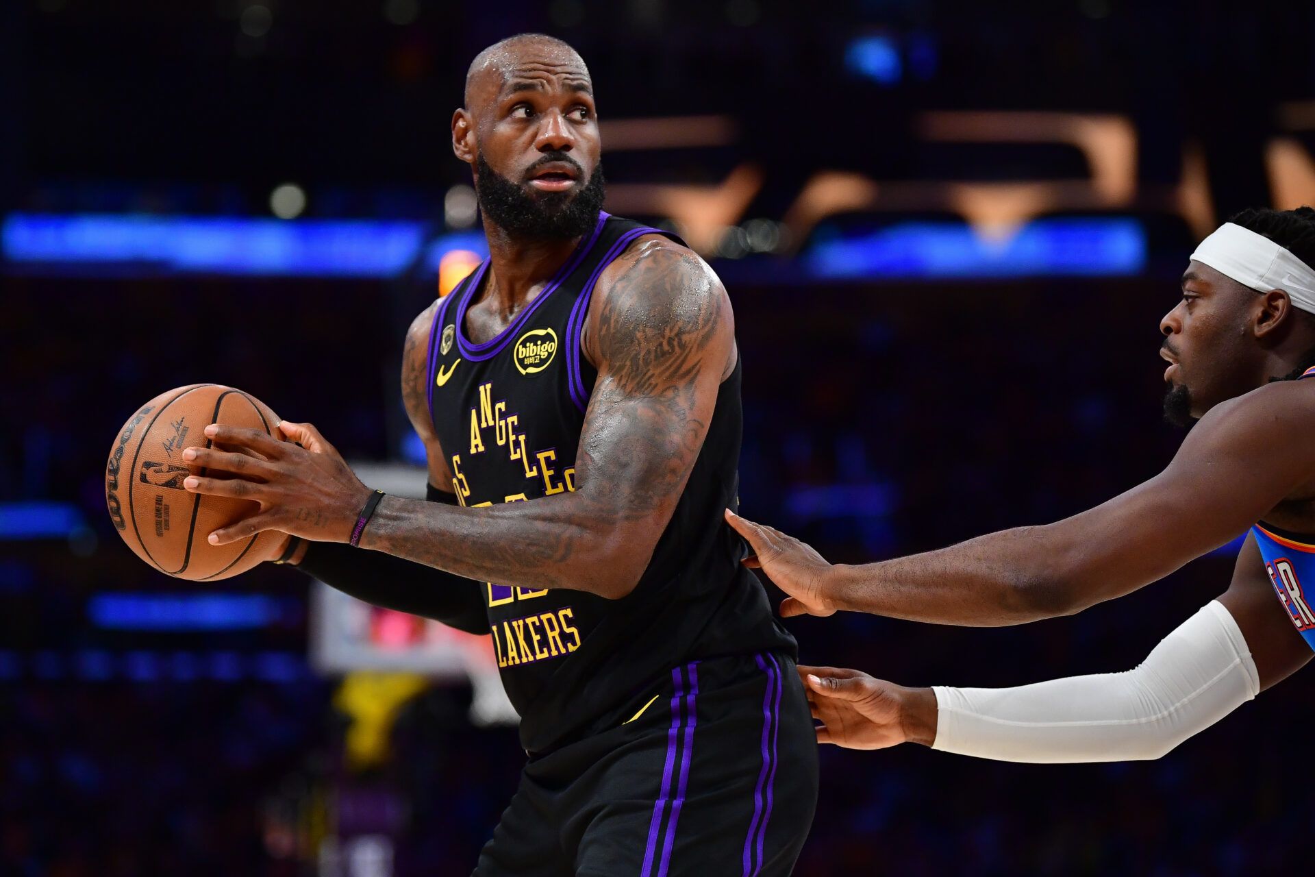 Los Angeles Lakers forward LeBron James (23) controls the ball against Oklahoma City Thunder guard Luguentz Dort (5) during the first half in game four of the second round of the 2026 NBA Playoffs at Crypto.com Arena.
