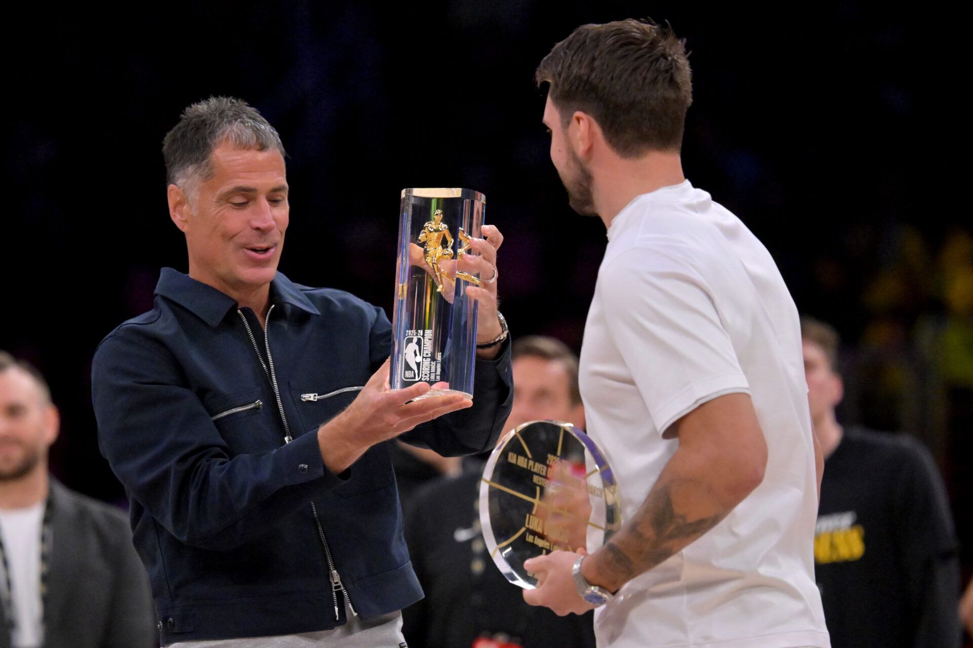 Los Angeles Lakers general manager Rob Pelinka shows off the NBA scoring champion trophy, along with the player of the month award give to guard Luka Doncic (77) prior to game two of the first round of the 2026 NBA Playoffs against the Houston Rockets at Crypto.com Arena.