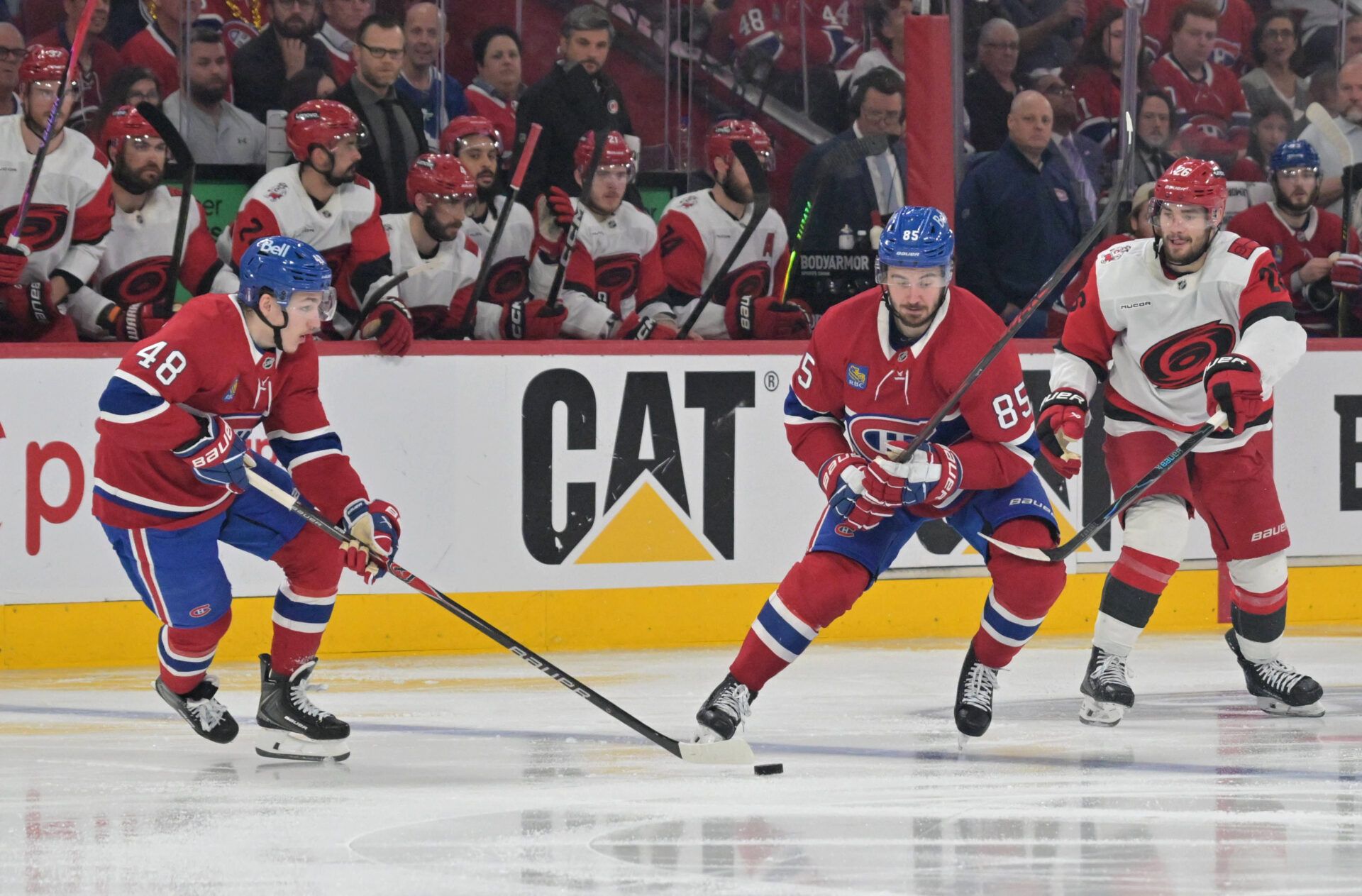 Montreal Canadiens defenseman Lane Hutson (48) takes the puck from left wing Alexandre Texier (85) in front of Carolina Hurricanes defenseman Sean Walker (26) during overtime in game three of the Eastern Conference Final of the 2026 Stanley Cup Playoffs at Bell Centre.