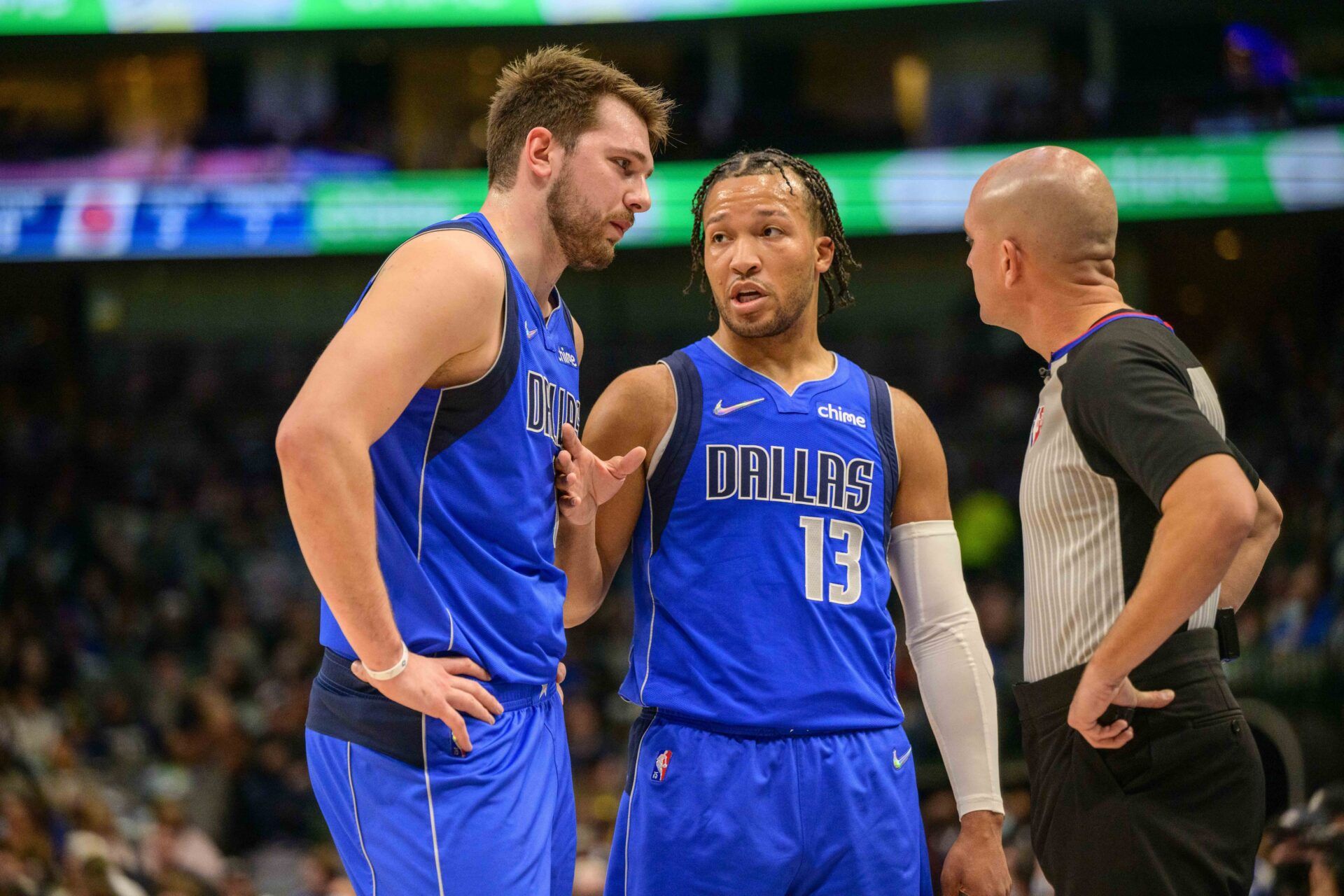 Dallas Mavericks guard Luka Doncic (77) and guard Jalen Brunson (13) talk with NBA referee Jacyn Goble (68) during the first quarter against the Detroit Pistons at the American Airlines Center.