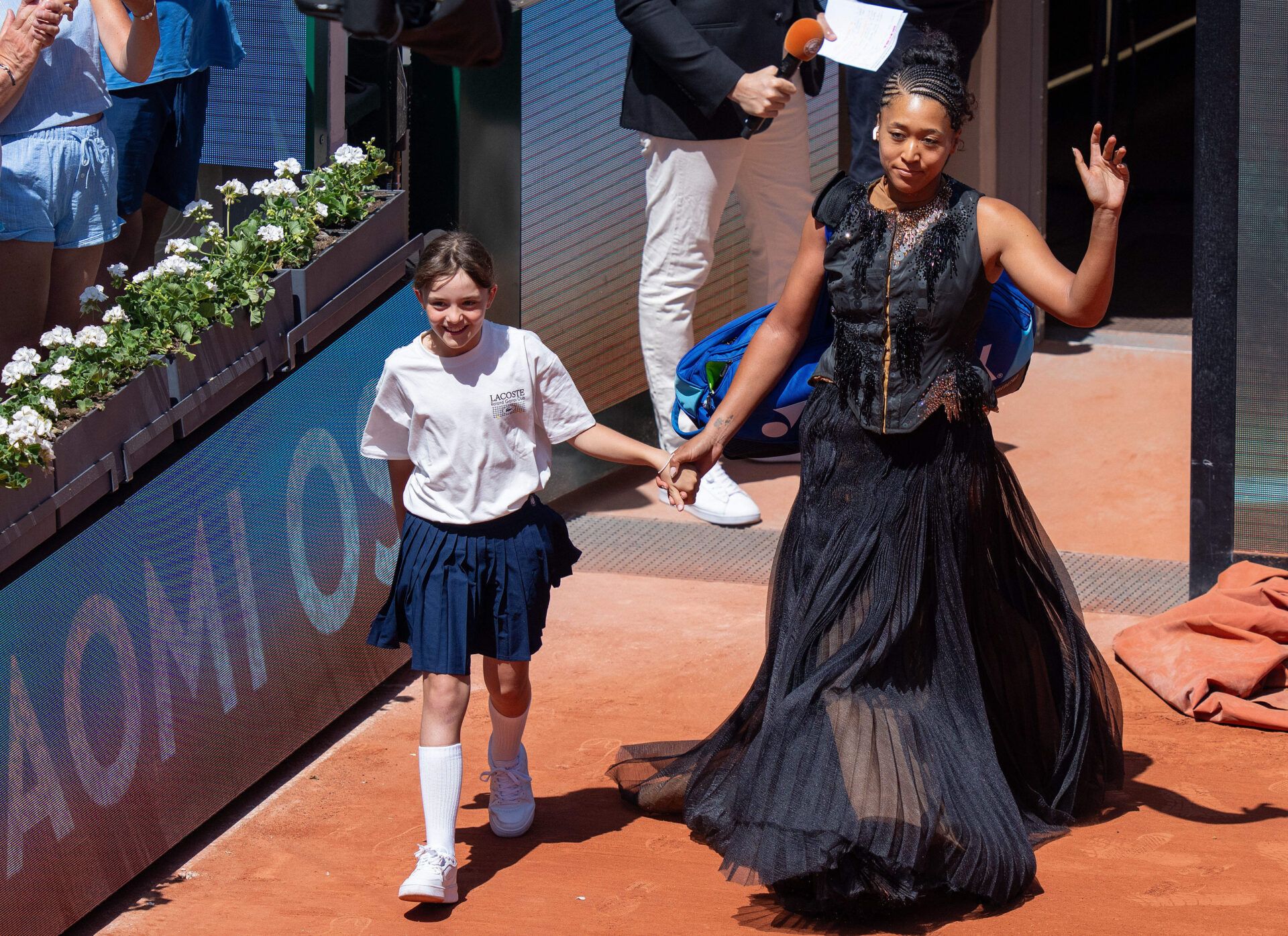 Naomi Osaka of Japan enters the court wearing a dress designed by Kevin Germanier for her match against Laura Siegemund of Germany on day three at Stade Roland Garros.