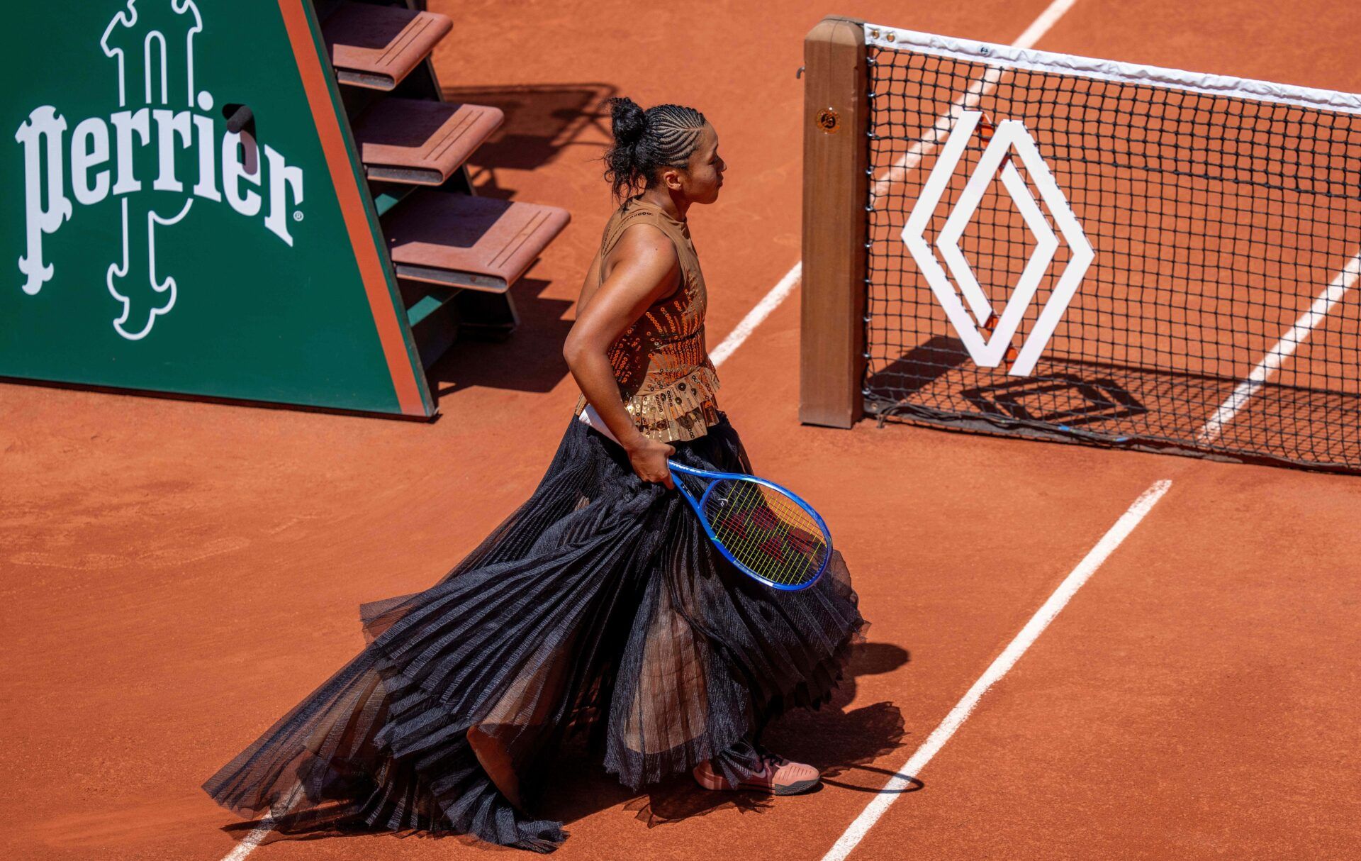 Naomi Osaka of Japan as she goes on the court for the coin toss in her dress designed by Kevin Germanier for her match against Laura Siegemund of Germany on day three at Stade Roland Garros.