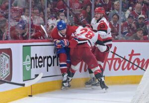 Montreal Canadiens defenseman Lane Hutson (48) is checked by Carolina Hurricanes left wing William Carrier (28) and left wing Eric Robinson (50) during the second period in game three of the Eastern Conference Final of the 2026 Stanley Cup Playoffs at Bell Centre. 