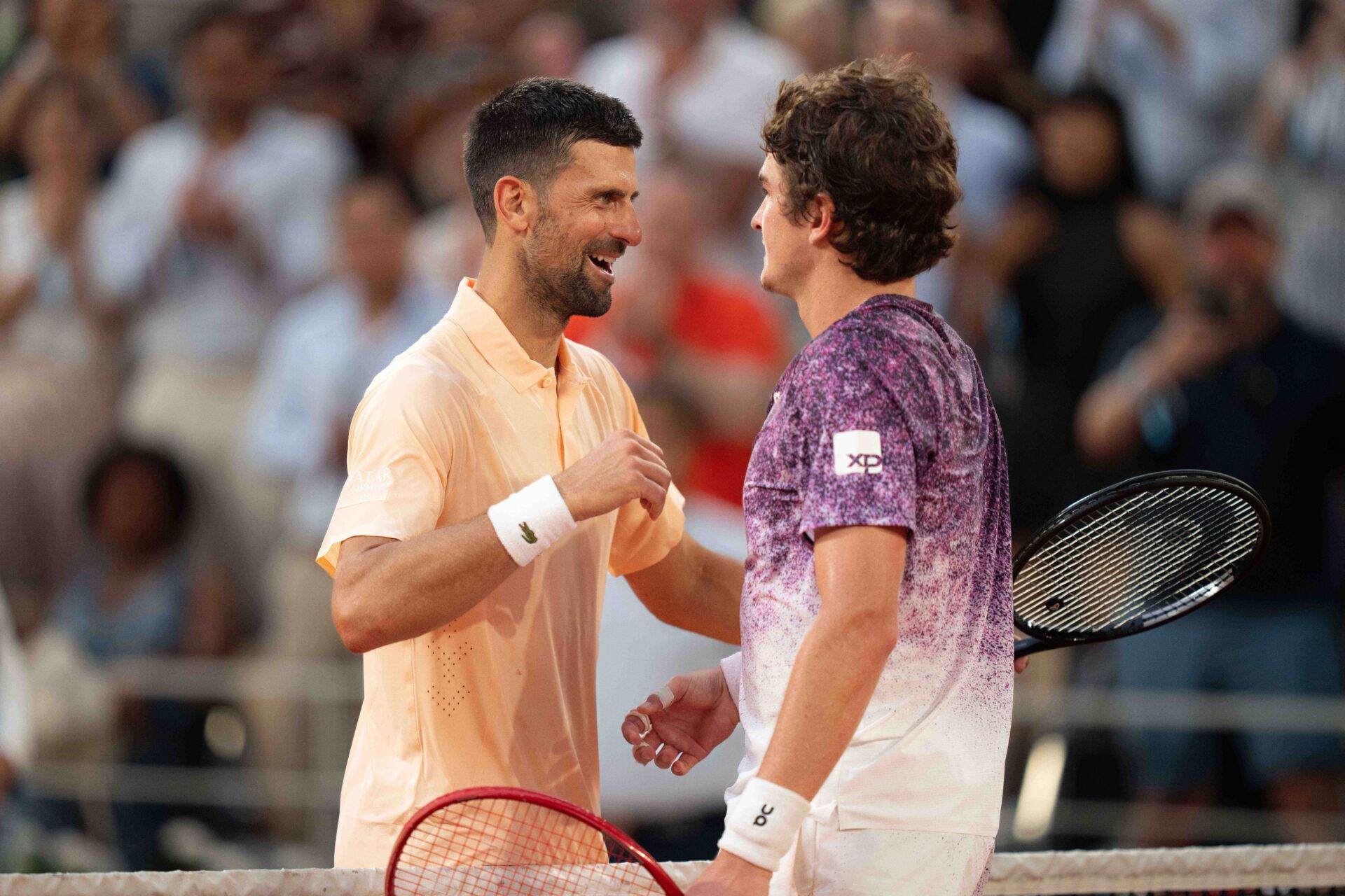 Joao Fonseca of Brazil and Novak Djokovic of Serbia at the net after their match on day six at Stade Roland Garros.