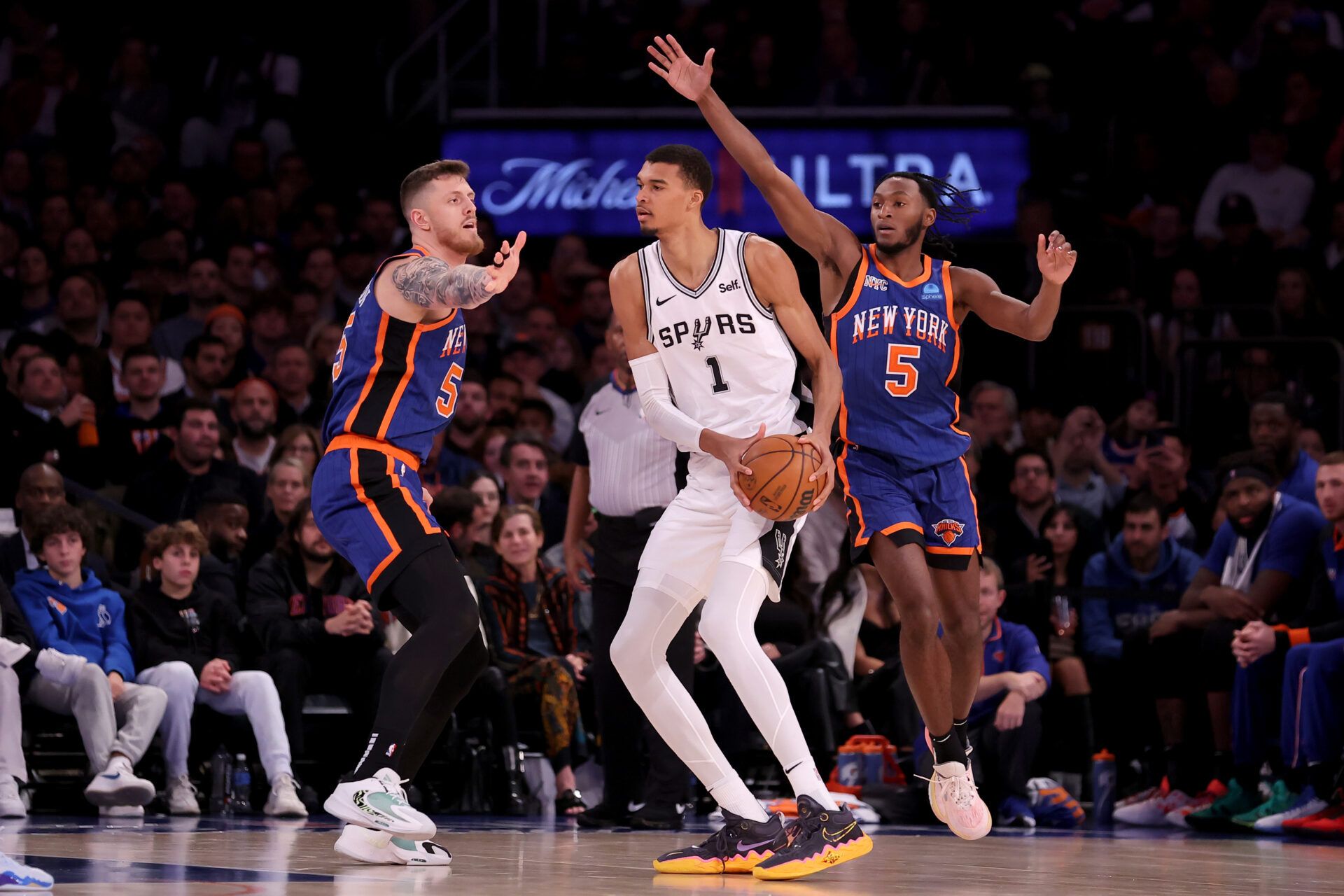 San Antonio Spurs center Victor Wembanyama (1) controls the ball against New York Knicks center Isaiah Hartenstein (55) and guard Immanuel Quickley (5) during the third quarter at Madison Square Garden.