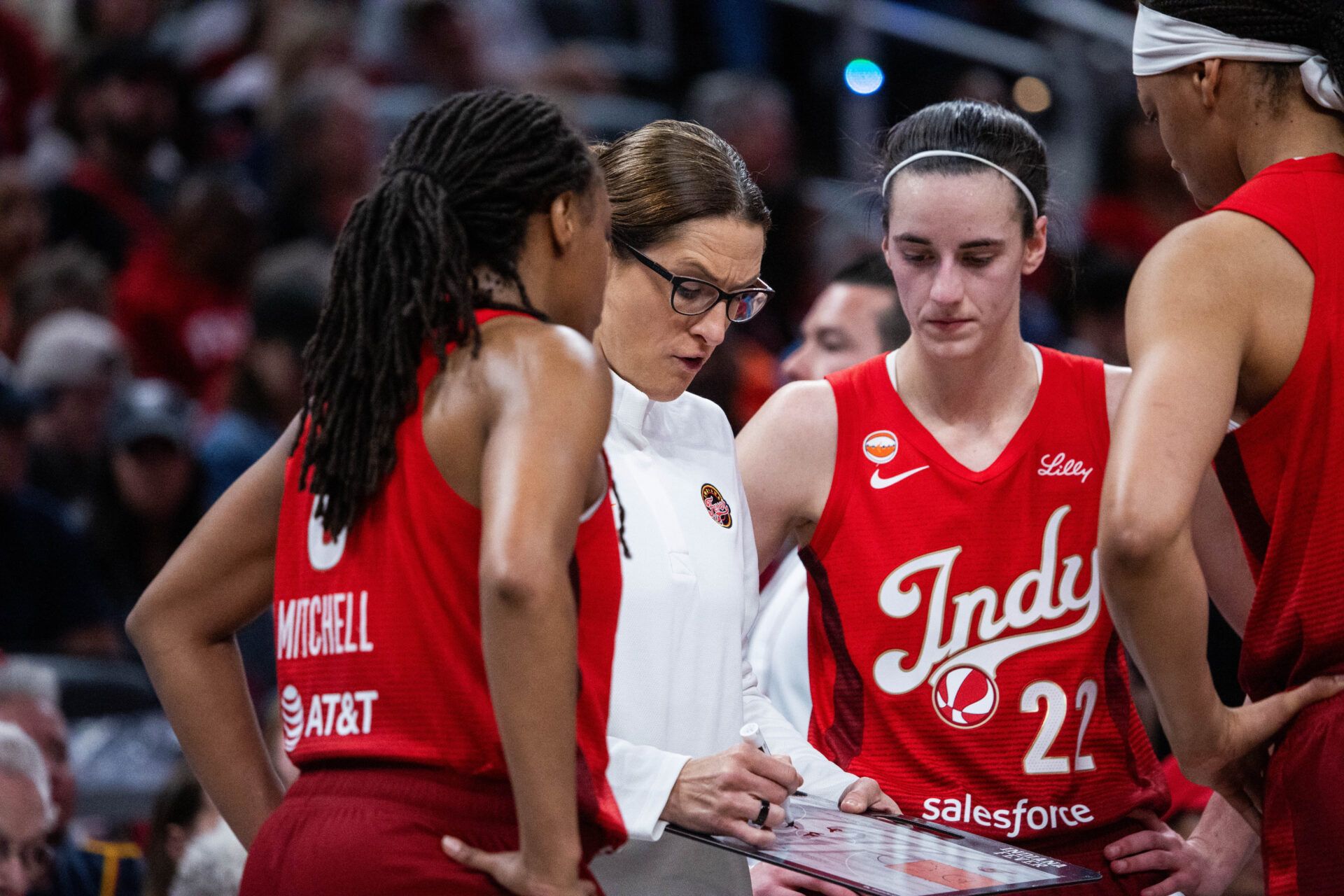Indiana Fever head coach Stephanie White talks to guard Kelsey Mitchell (0) and  Caitlin Clark (22)  in the second half against the Washington Mystics at Gainbridge Fieldhouse.