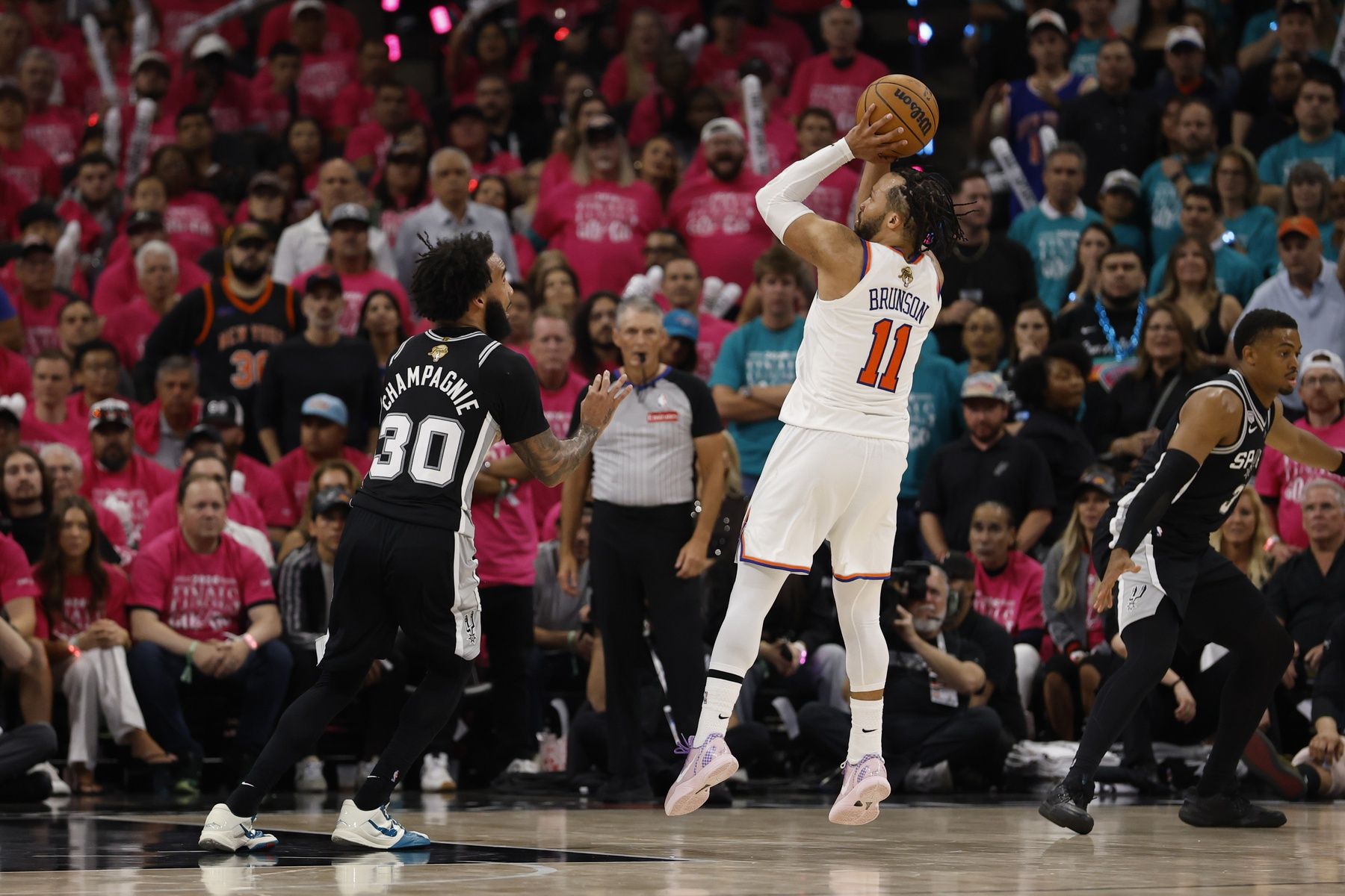New York Knicks guard Jalen Brunson (11) shoots the ball past San Antonio Spurs forward Julian Champagnie (30) in the second half during game one of the 2026 NBA Finals at Frost Bank Center.