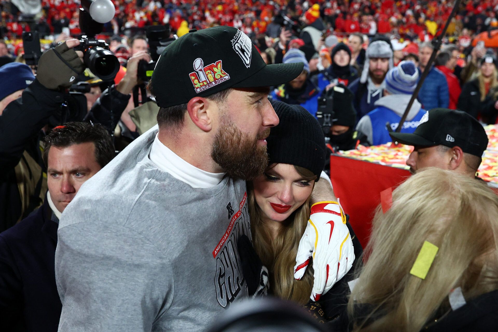 Recording artist Taylor Swift  and Kansas City Chiefs tight end Travis Kelce (87) react after the AFC Championship game against the Buffalo Bills at GEHA Field at Arrowhead Stadium.