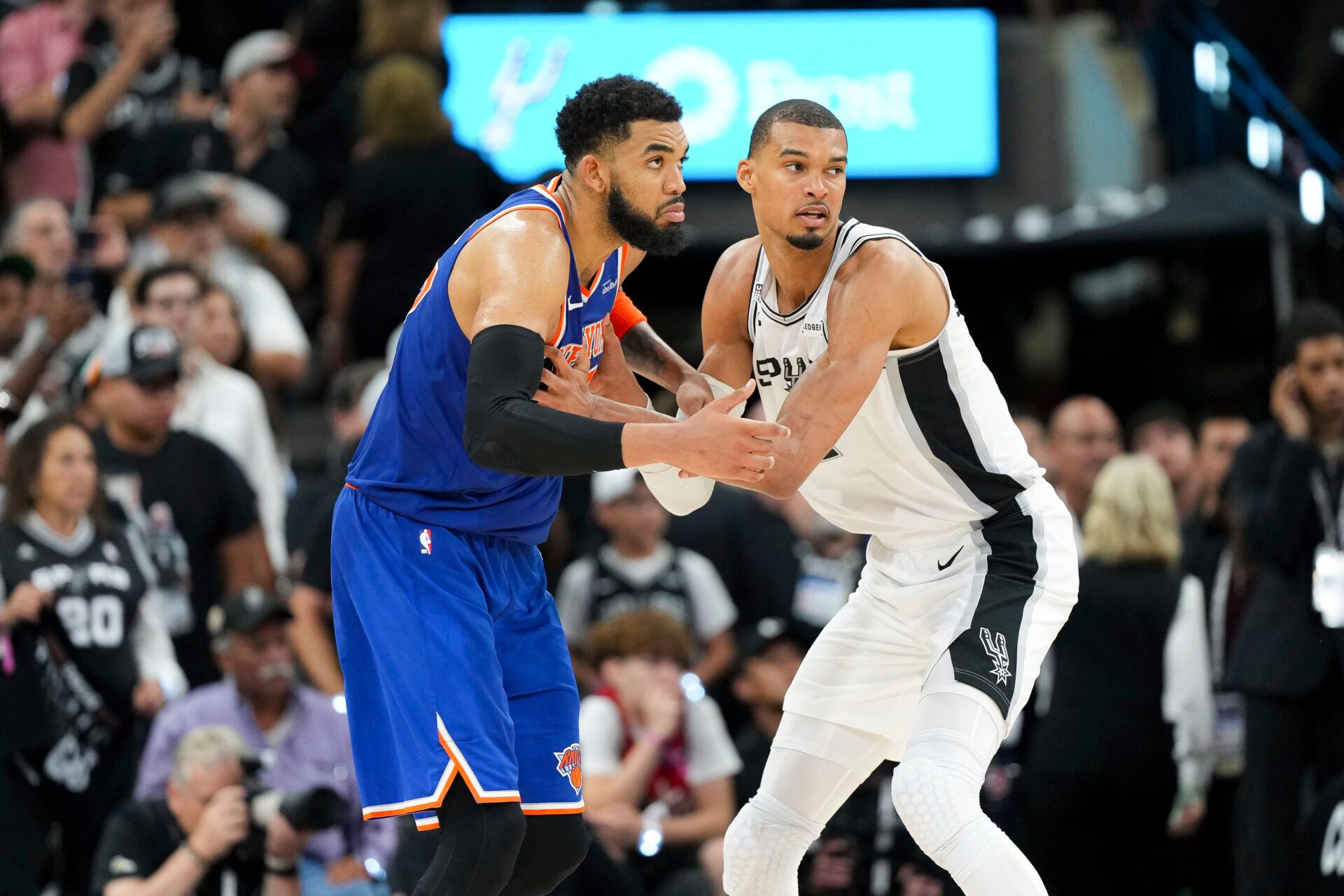 New York Knicks center Karl-Anthony Towns (32) and San Antonio Spurs forward Victor Wembanyama (1) look for the ball in the second half during game two of the 2026 NBA Finals at Frost Bank Center.
