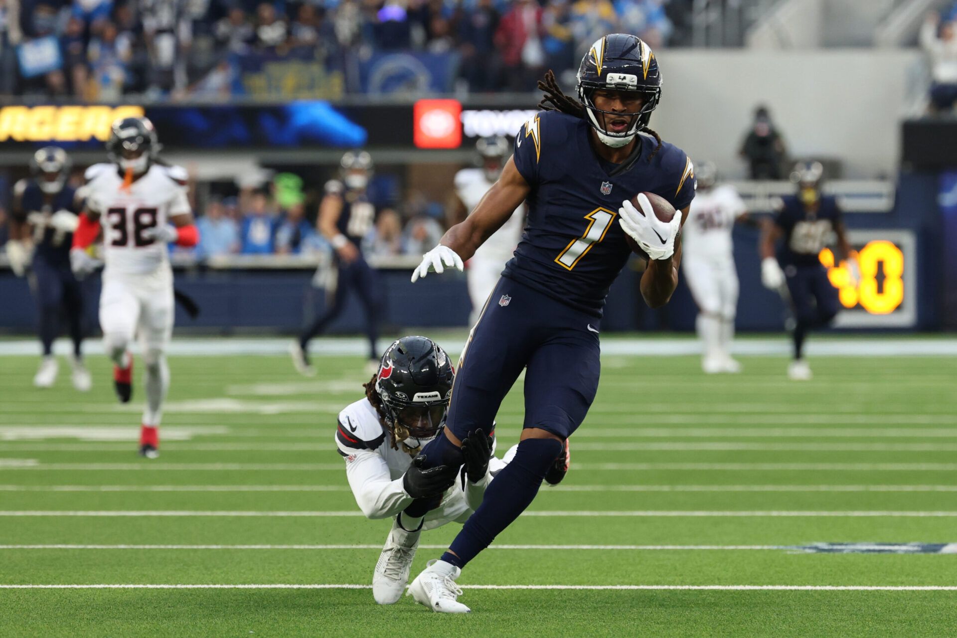 Los Angeles Chargers wide receiver Quentin Johnston (1) runs after the catch as Houston Texans cornerback Tremon Smith (11) defends during the first half at SoFi Stadium.