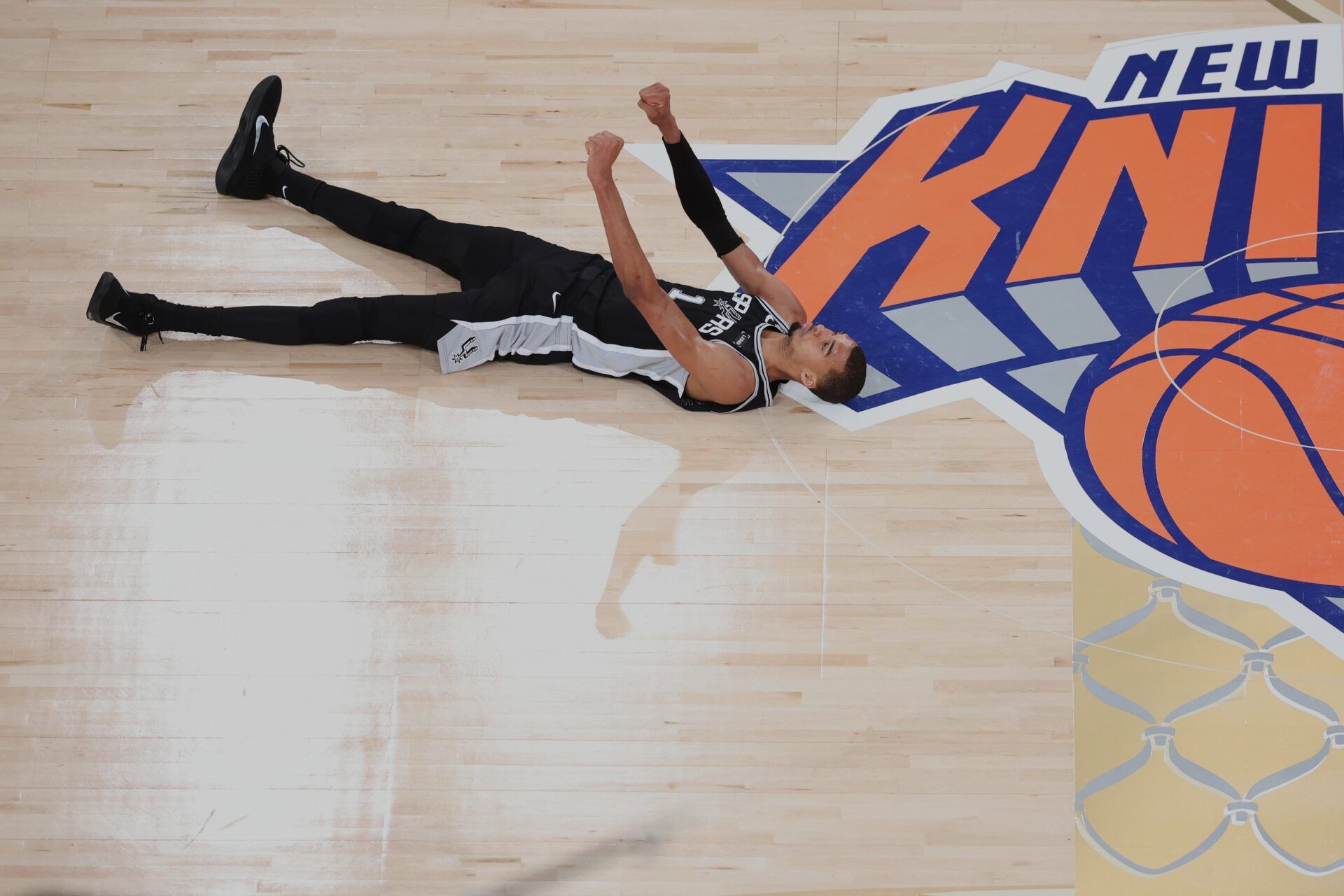 San Antonio Spurs forward Victor Wembanyama (1) lies on the court and reacts against the New York Knicks during game three of the 2026 NBA Finals in the fourth quarter at Madison Square Garden.