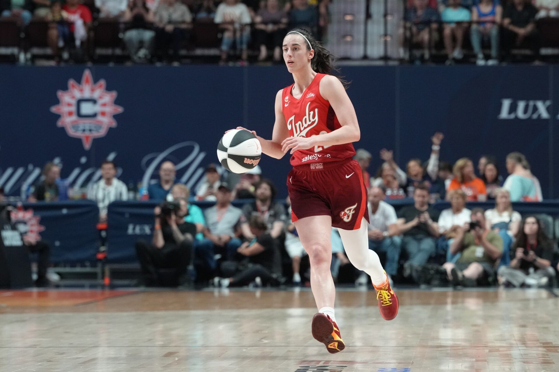 Indiana Fever guard Caitlin Clark (22) dribbles the ball up the court against the Connecticut Sun during the second half at Mohegan Sun Arena.