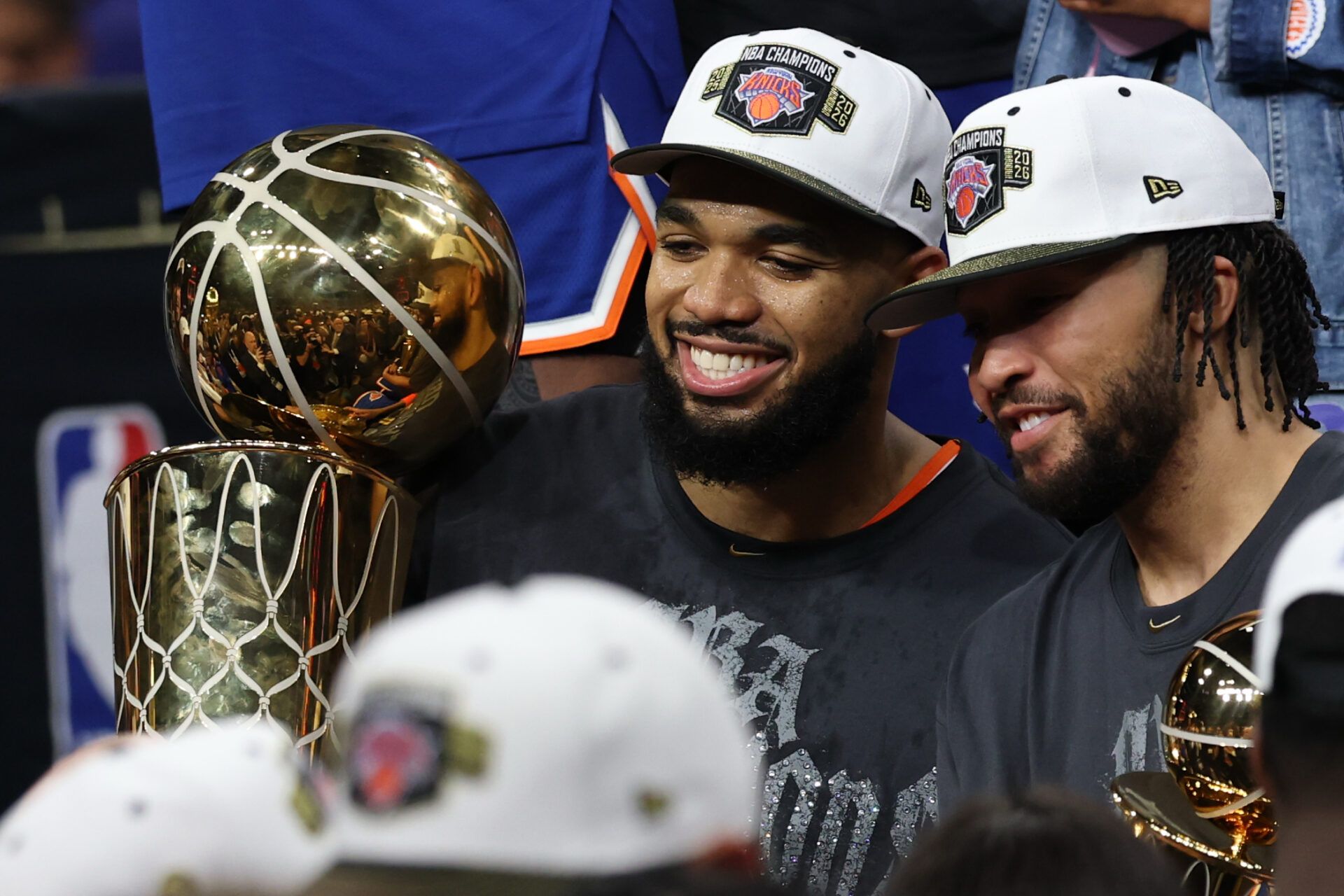 New York Knicks center Karl-Anthony Towns (L) holds the Larry O'Brien championship trophy as Knicks guard Jalen Brunson (R) holds the Finals MVP trophy after game five of the 2026 NBA Finals against the San Antonio Spurs at Frost Bank Center.