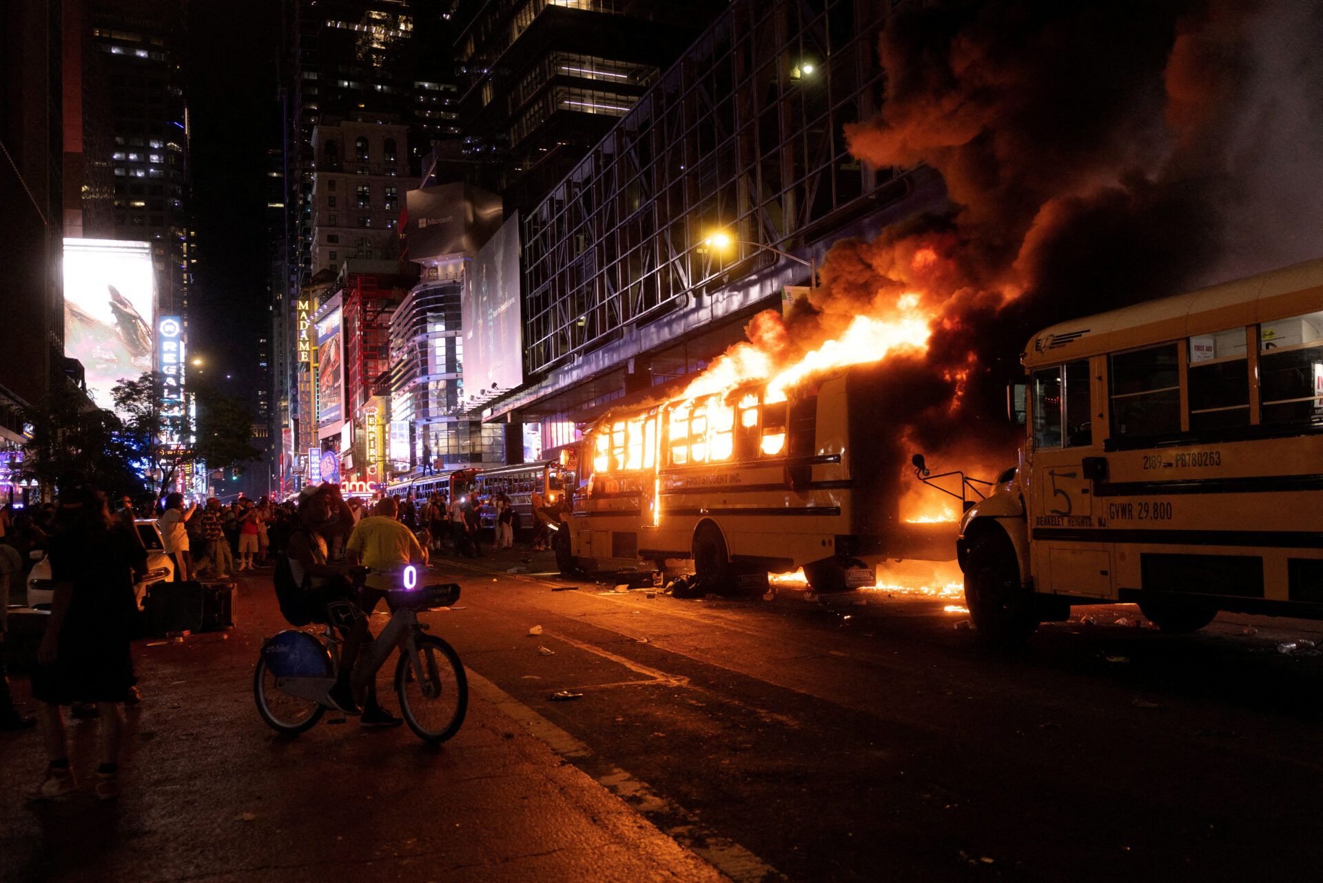 Revellers and fans celebrating the New York Knicks' win over the San Antonio Spurs and World Cup festivities watch as a city shuttle bus catches fire outside the Port Authority Bus Terminal in New York, U.S., June 14, 2026. The shuttles had been brought in to transport spectators to and from the New York/New Jersey stadium for the 2026 FIFA World Cup. REUTERS/Ed Ou     TPX IMAGES OF THE DAY     REFILE- ADDING COUNTRY NAME IN CAPTION
