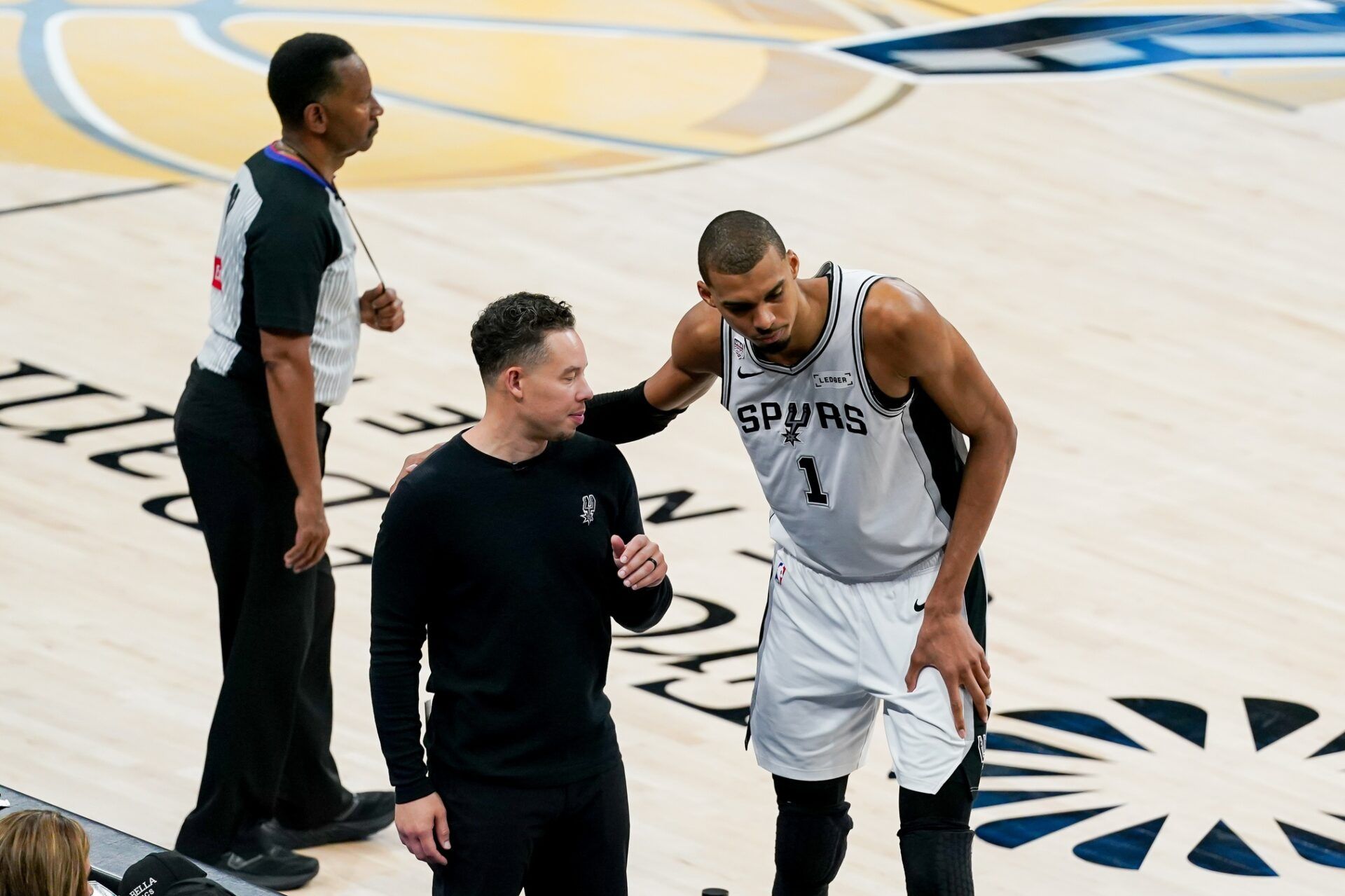 San Antonio Spurs head coach Mitch Johnson talks with San Antonio Spurs forward Victor Wembanyama (1) against the New York Knicks in the second half during game five of the 2026 NBA Finals at Frost Bank Center.