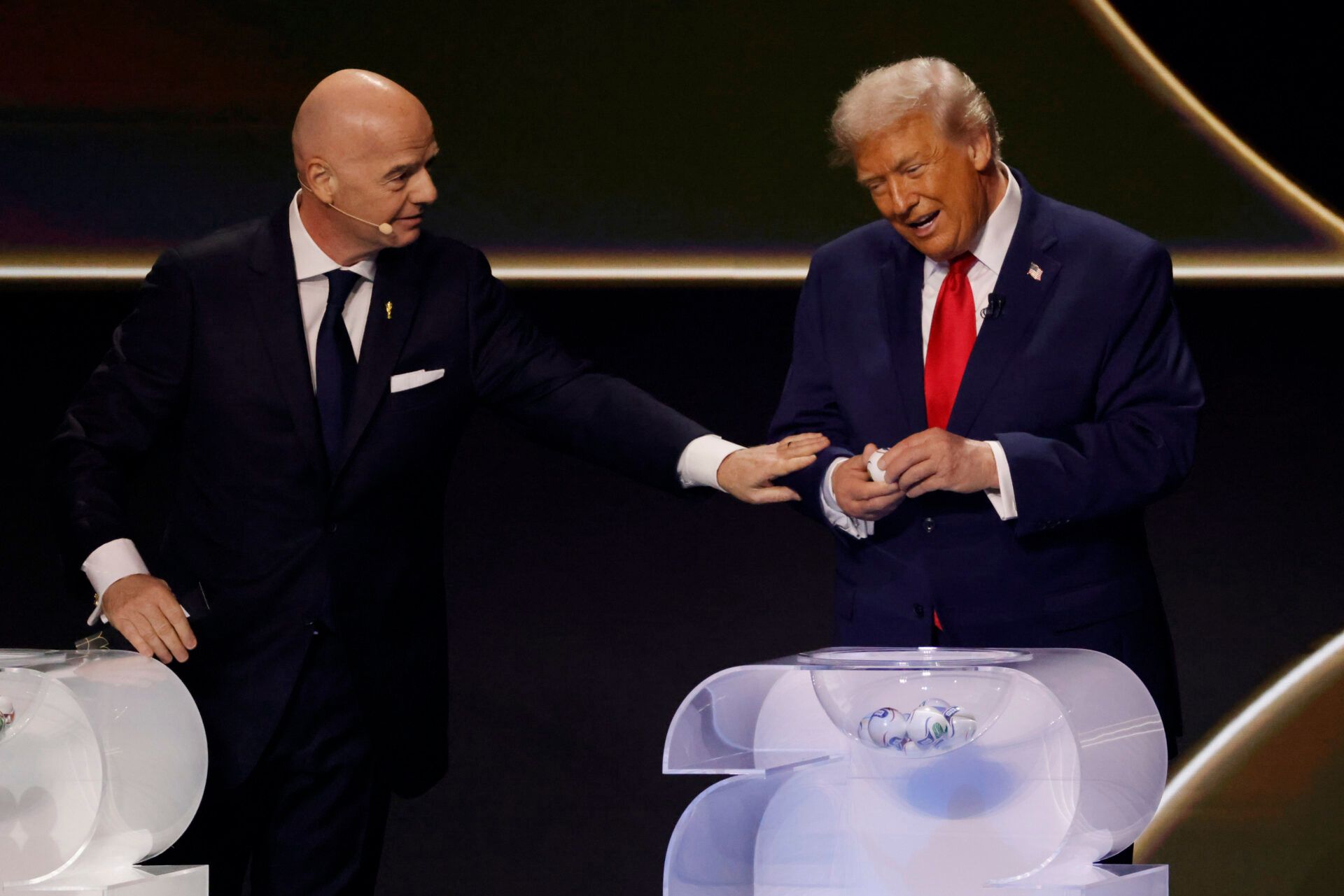 U.S. President Donald Trump (R) opens a draw ball as FIFA President Gianni Infantino (L) gestures during the FIFA World Cup 2026 Final Draw at John F. Kennedy Center for the Performing Arts.