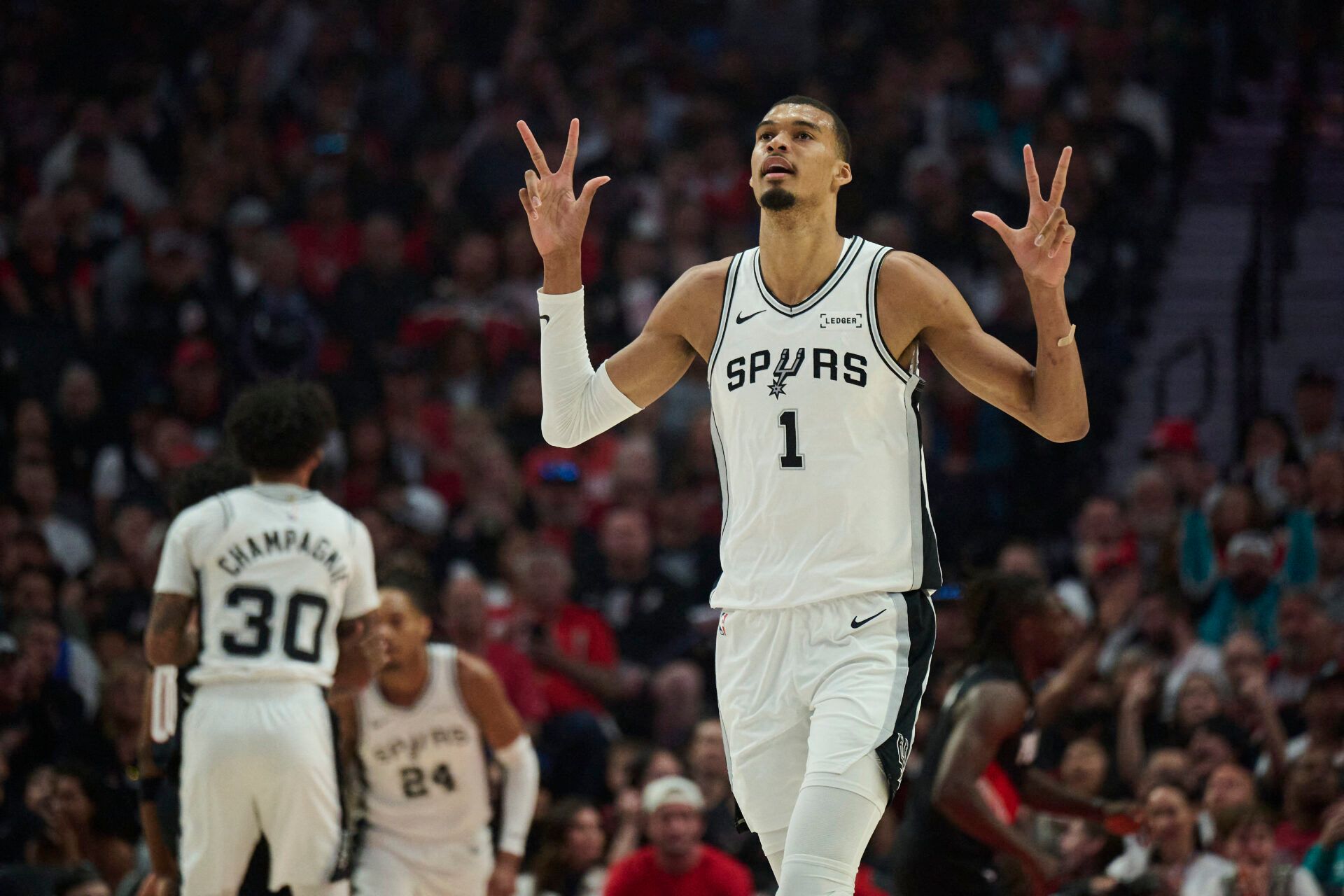 San Antonio Spurs forward Victor Wembanyama (1) celebrates a three point basket by guard De'aaron Fox (4) during the first half of game four of the first round of the 2026 NBA Playoffs against the Portland Trail Blazers at Moda Center.