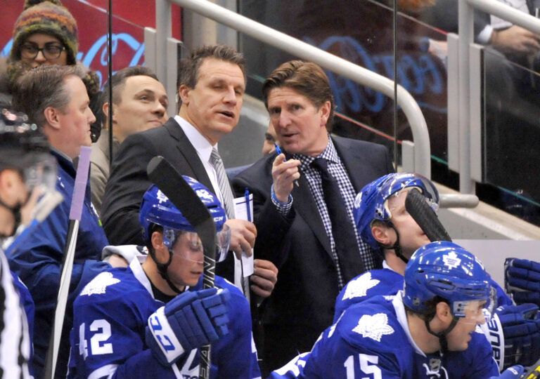 Toronto Maple Leafs head coach Mike Babcock (right) gestures as he speaks with assistant coach Jim Hiller during a time out against Columbus Blue Jackets at Air Canada Centre.