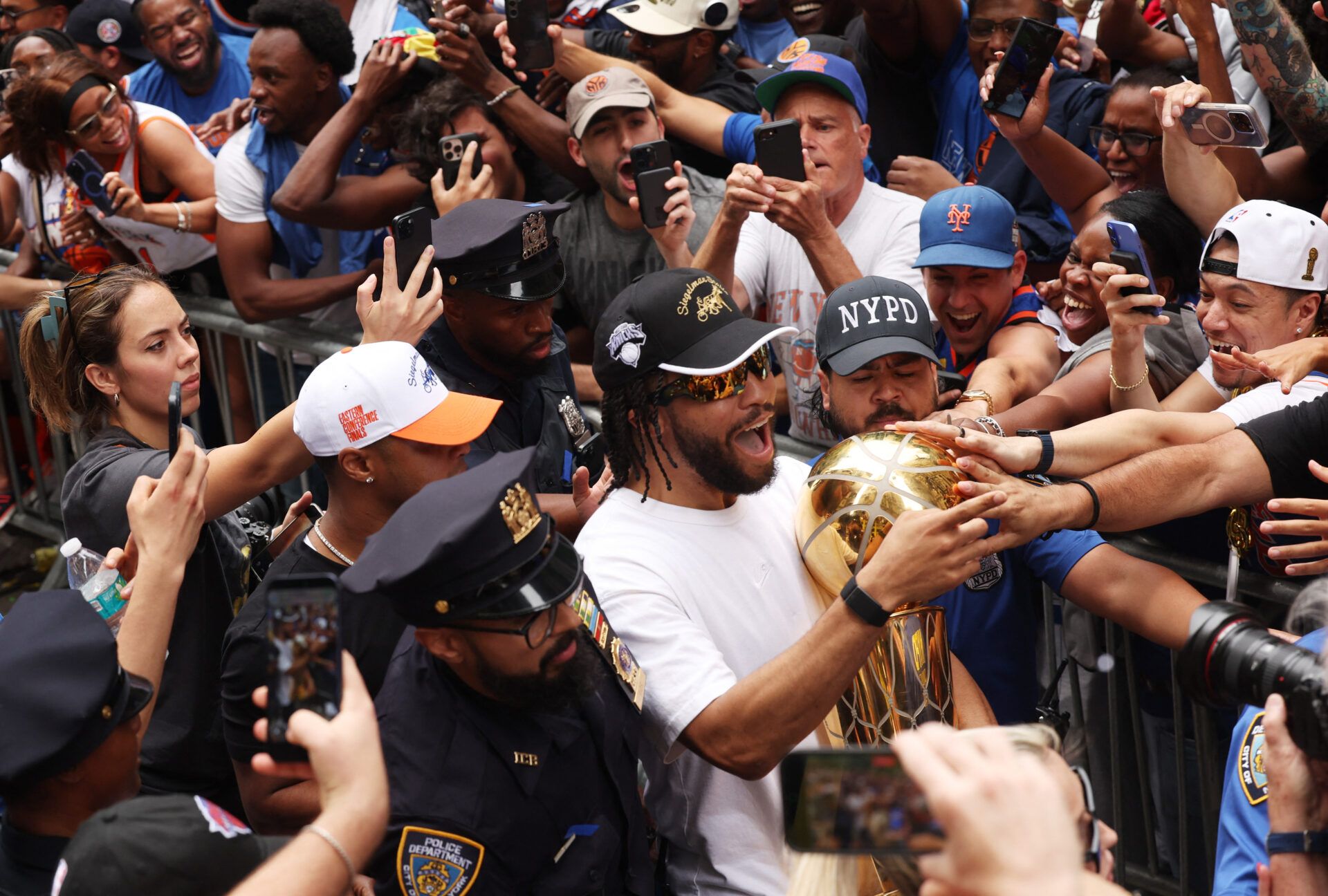 Basketball - NBA - New York Knicks Parade - New York City, New York, U.S. - June 18, 2026 New York Knicks' Jalen Brunson celebrates with the Larry O'Brien Championship Trophy as fans reach towards him during the parade REUTERS/Shannon Stapleton
