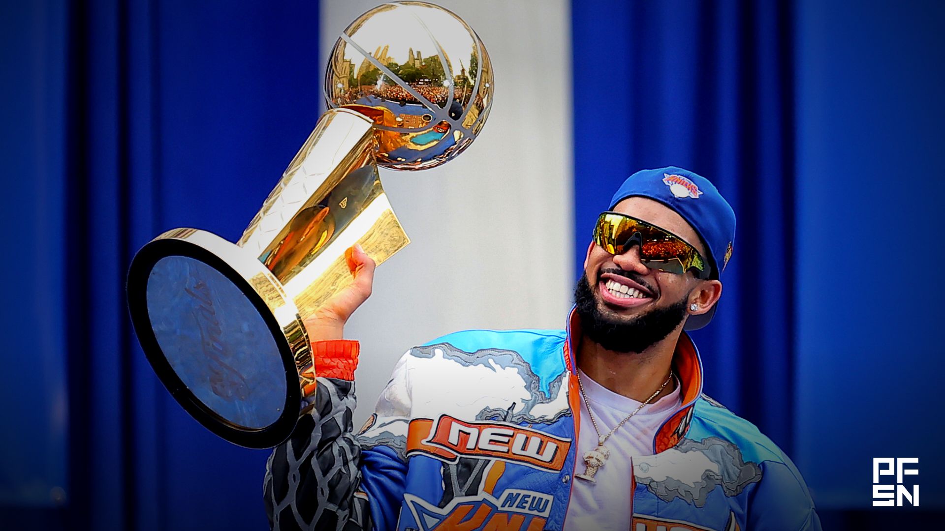 New York Knicks center Karl-Anthony Towns holds up the Larry O'Brien championship trophy during a ceremony at city hall after the championship parade.
