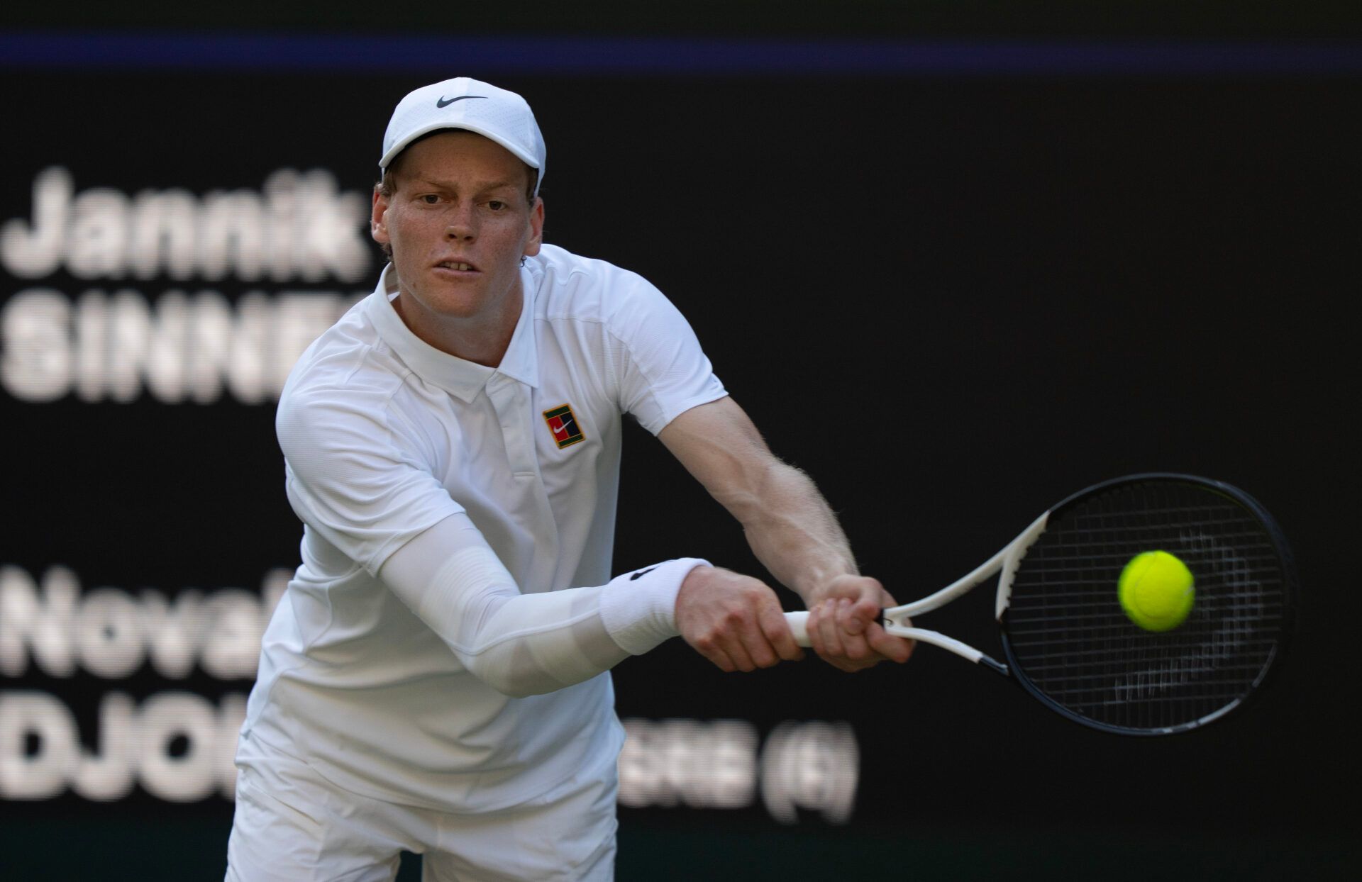 Jannik Sinner of Italy returns a shot during his match against Novak Djokovic of Serbia on day 12 at All England Lawn Tennis and Croquet Club.