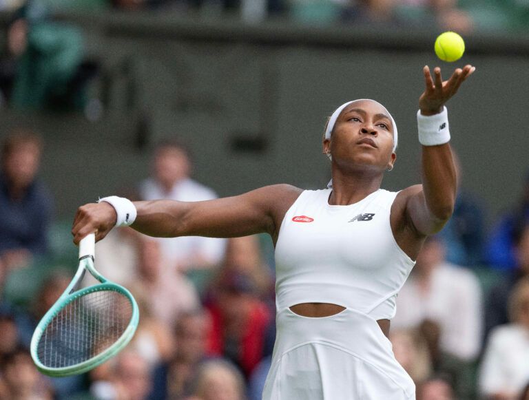 Coco Gauff of the United States tosses the ball to serve during her match against Caroline Dolehide of the United States (not shown) on day one of The Championships at All England Lawn Tennis and Croquet Club.