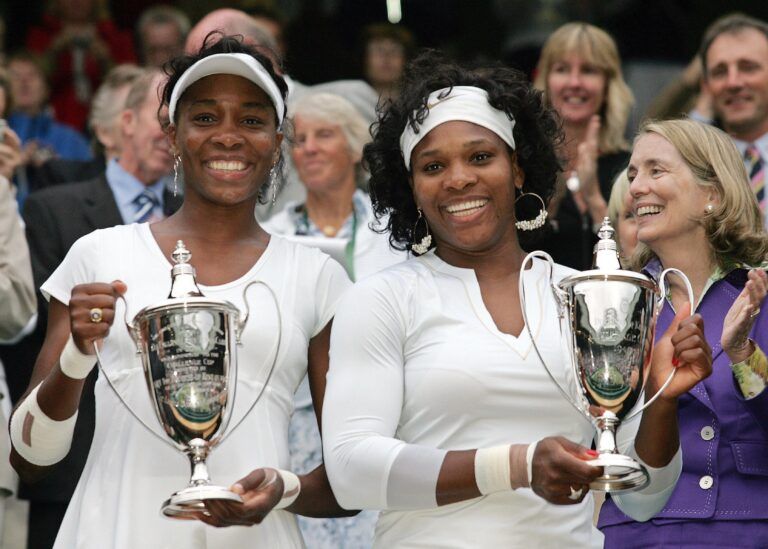Venus Williams (left) and Serena Williams (right) (USA) pose with their trophies after defeating Lisa Raymond and Samantha Stosur (not pictured) in the doubles finals of the 2008 Wimbledon Championships at the All England Lawn Tennis Club 6-2, 6-2.
