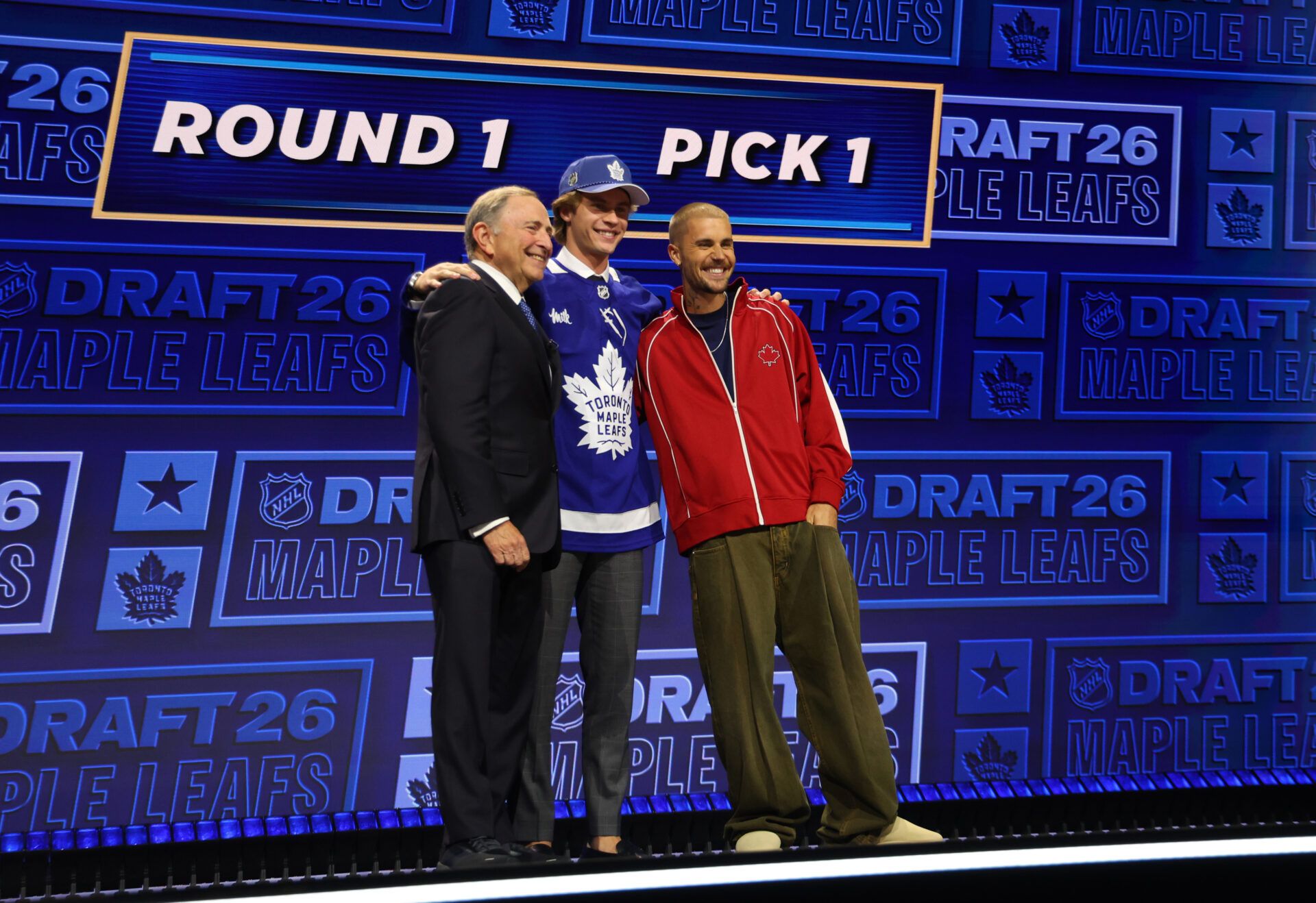 Gavin McKenna poses with NHL commissioner Gary Bettman and singer Justin Bieber after being selected with the first pick in the first round of the 2026 NHL Draft by the Toronto Maple Leafs at KeyBank Center.