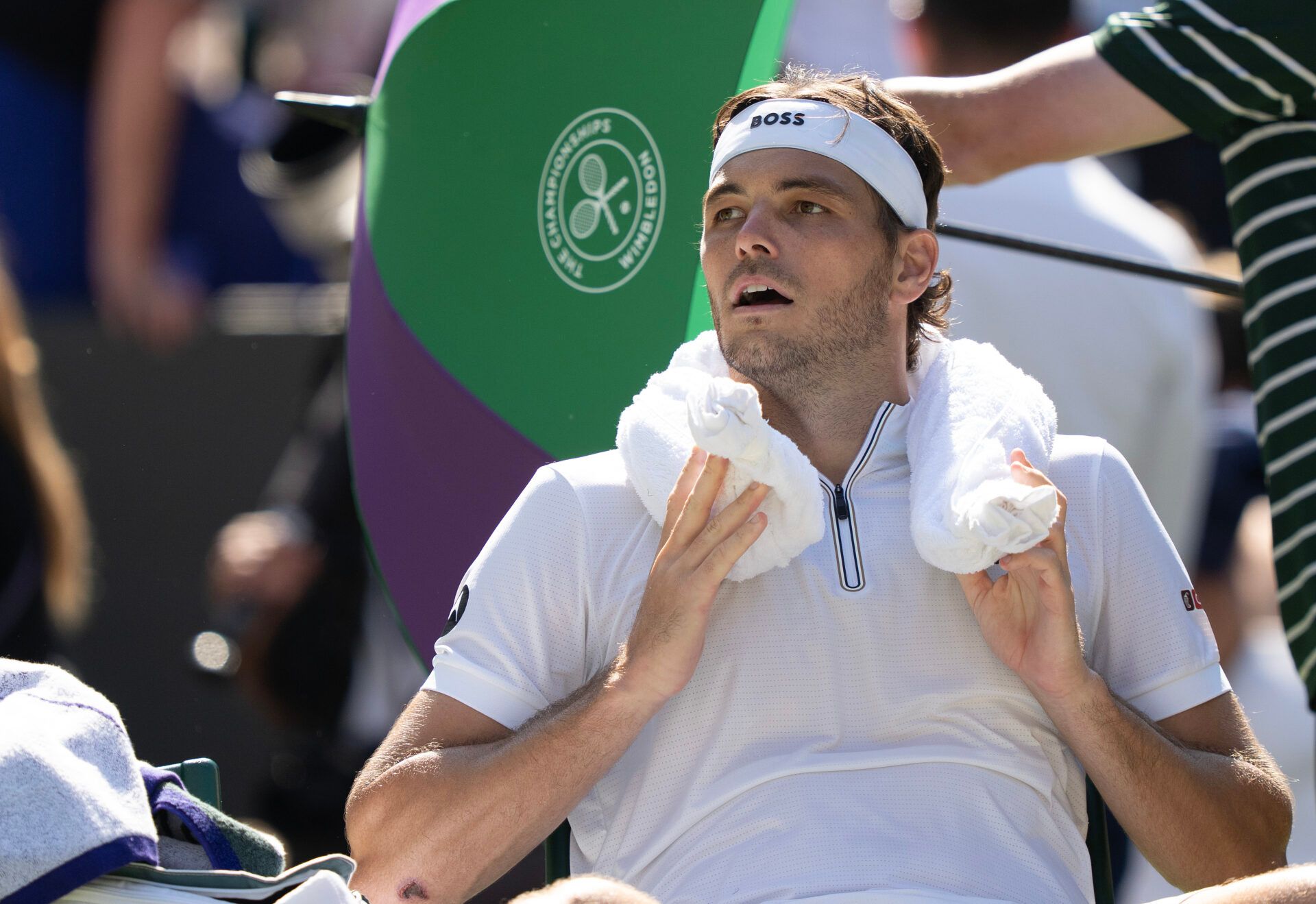 Taylor Fritz of the United States uses an ice towel at a change of ends during his match against Carlos Alcaraz of Spain on day 12 at All England Lawn Tennis and Croquet Club.