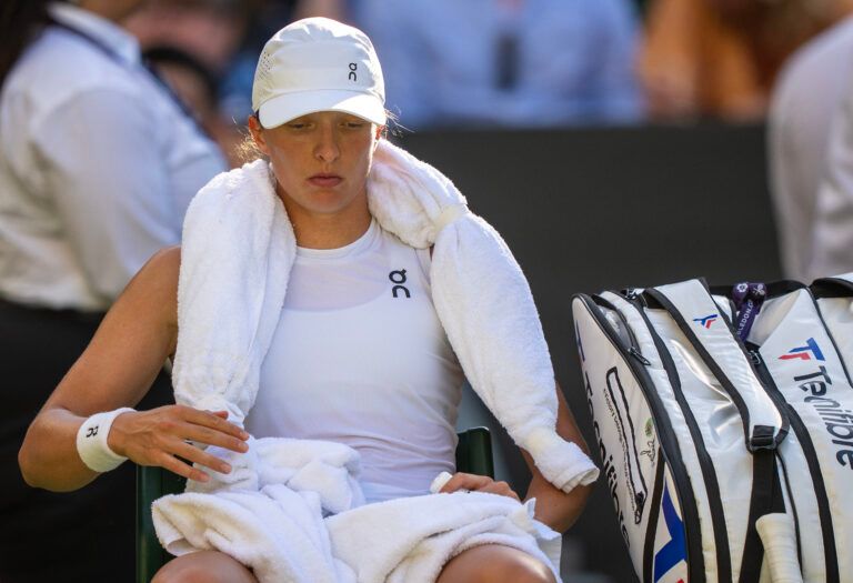 Iga Swiatek of Poland keep cool with an ice towel at a change of ends during her match against Belinda Bencic of Switzerland on day 11 at All England Lawn Tennis and Croquet Club.