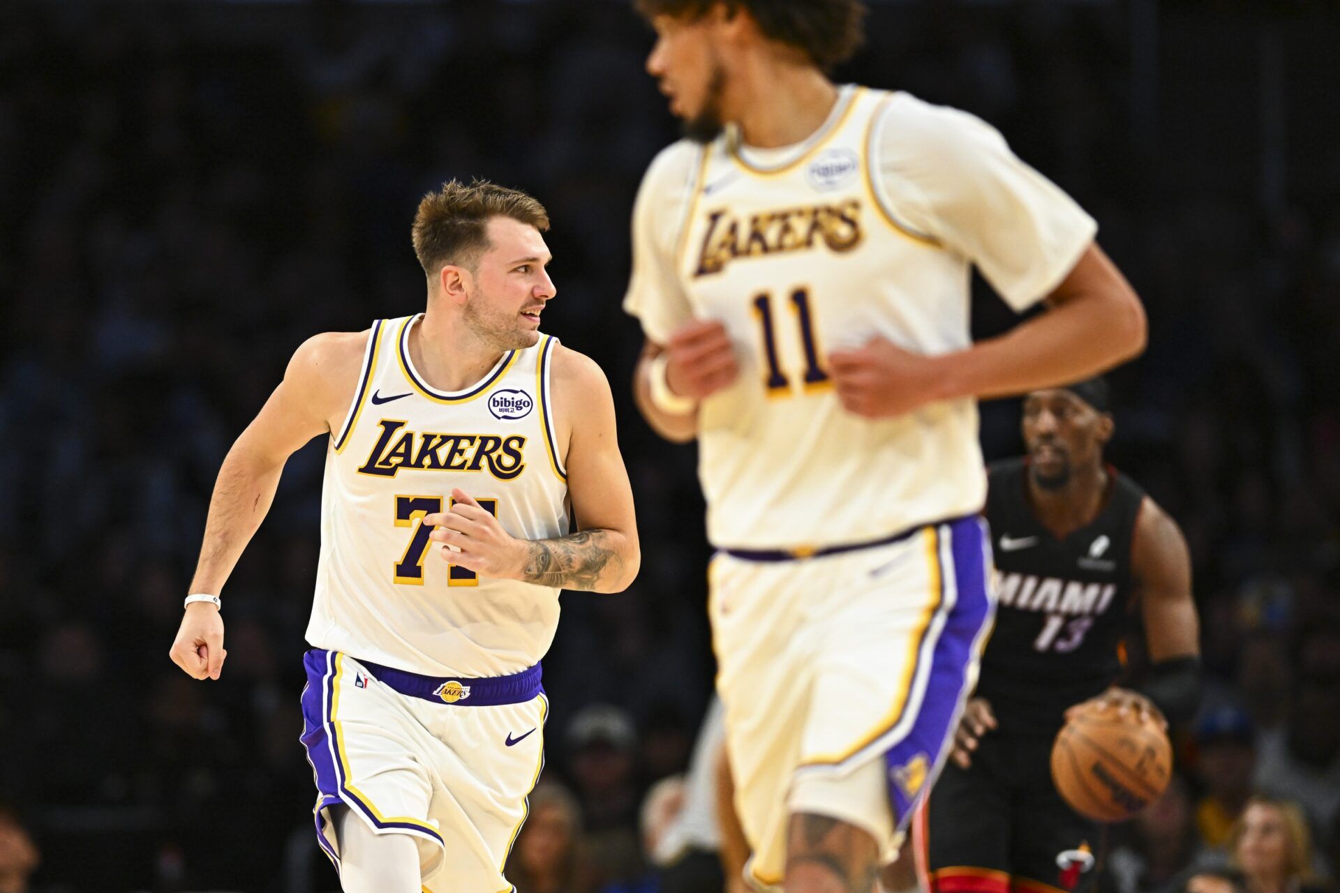 Los Angeles Lakers guard Luka Dončić (77) runs down the court with center Jaxson Hayes (11) against Miami Heat center/forward Bam Adebayo (13) during the first half at Crypto.com Arena.