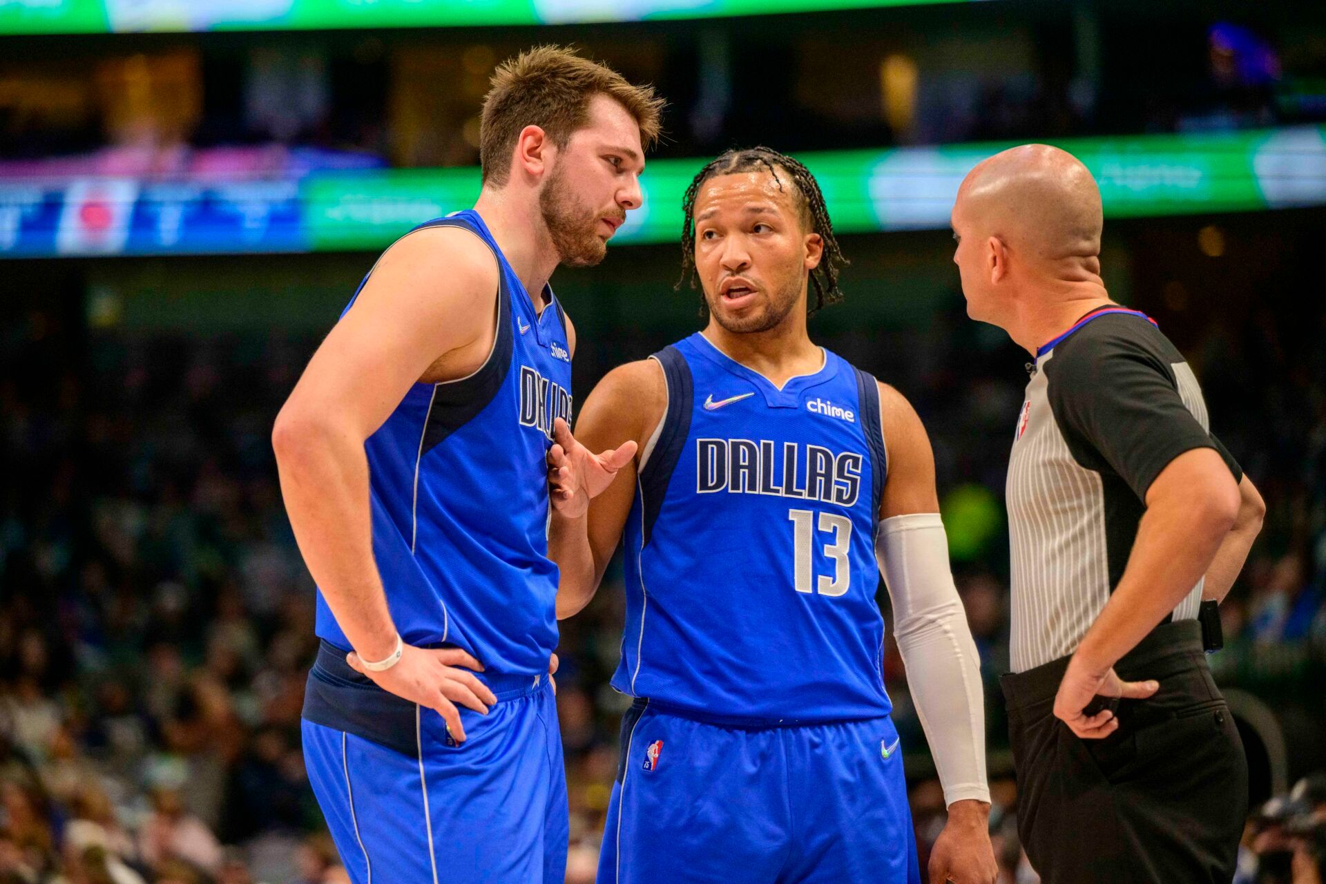 Dallas Mavericks guard Luka Doncic (77) and guard Jalen Brunson (13) talk with NBA referee Jacyn Goble (68) during the first quarter against the Detroit Pistons at the American Airlines Center.