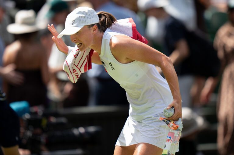 Iga Swiatek of Poland talks to her box as she leaves the court after losing the first set during her match against Alexandra Eala of the Philippines on day six at All England Lawn Tennis and Croquet Club.