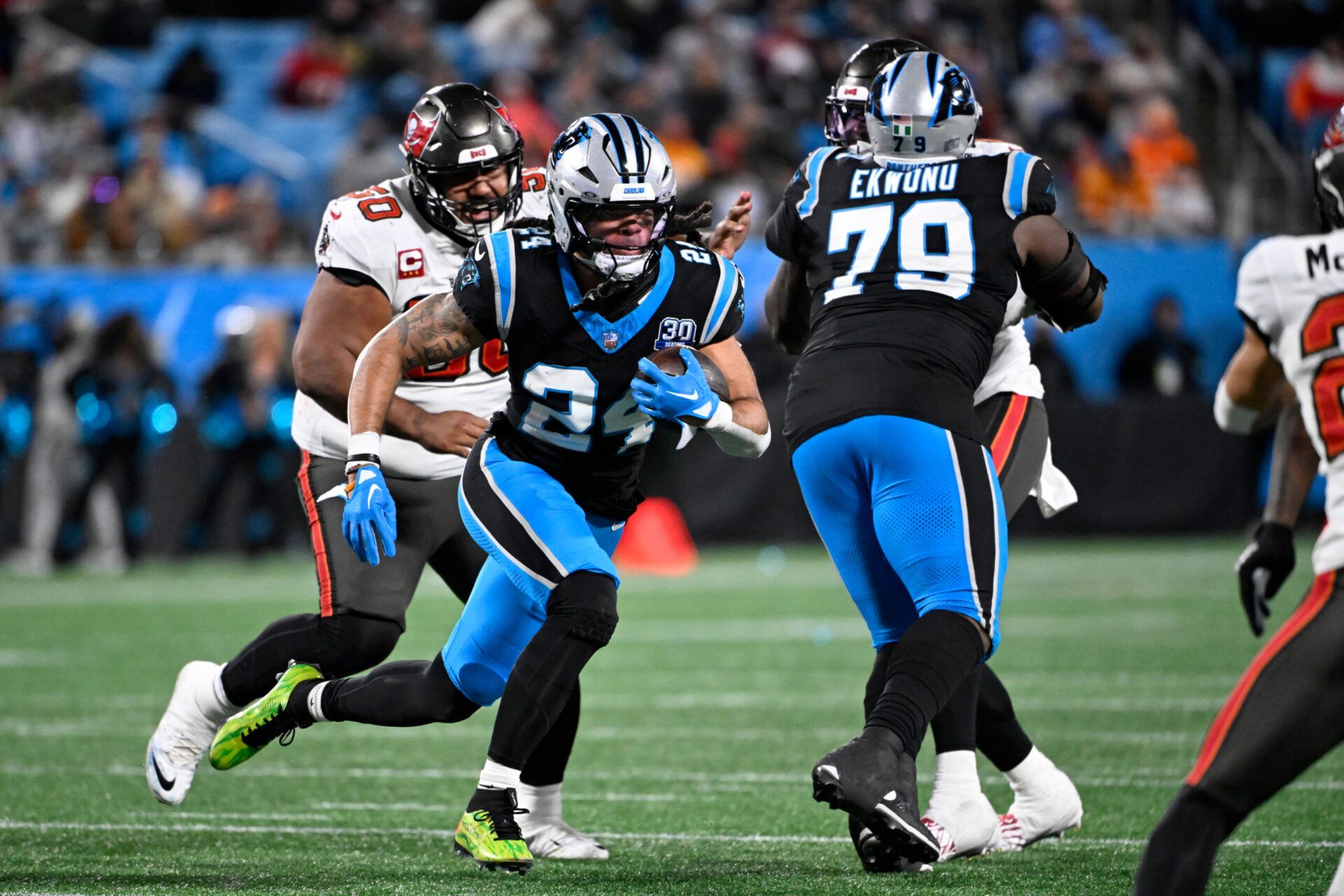 Carolina Panthers running back Jonathon Brooks (24) with the ball as Tampa Bay Buccaneers defensive tackle Vita Vea (50) defends in the third quarter at Bank of America Stadium.